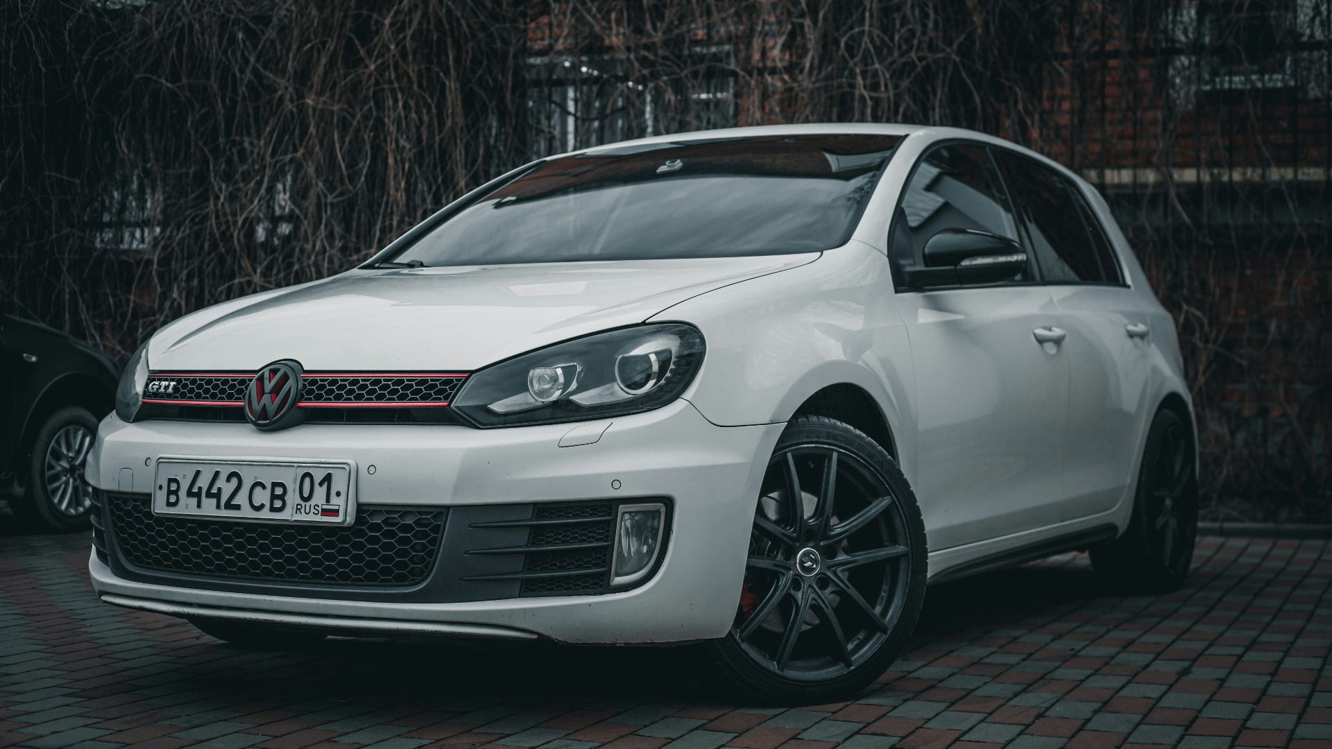 a white car parked in front of a brick building