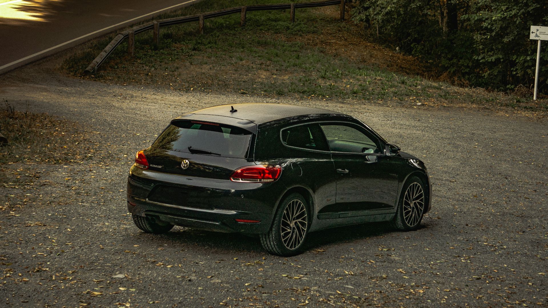 a black car parked on the side of a road