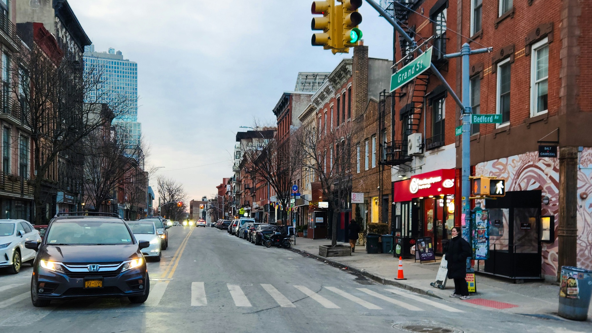 A city street filled with traffic next to tall buildings