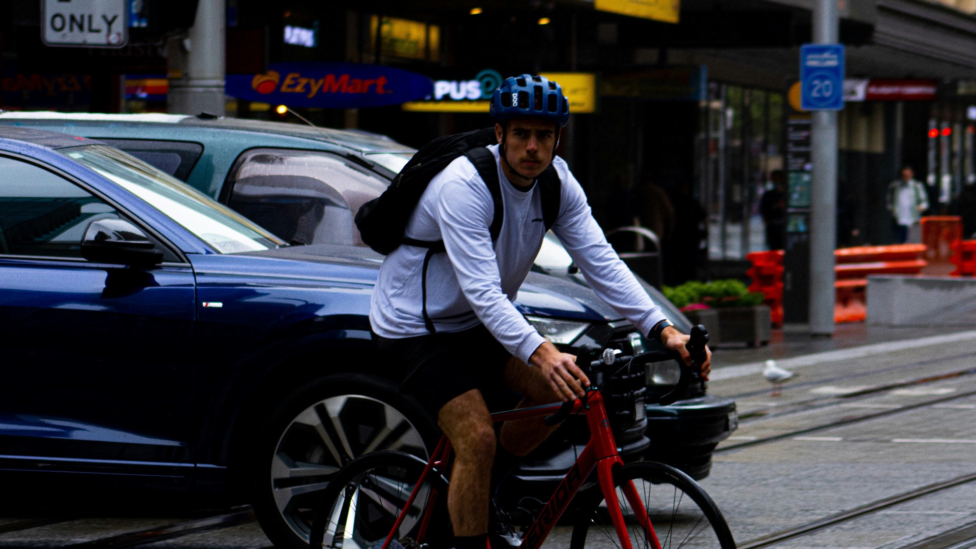 a man riding a bike down a street next to a traffic light