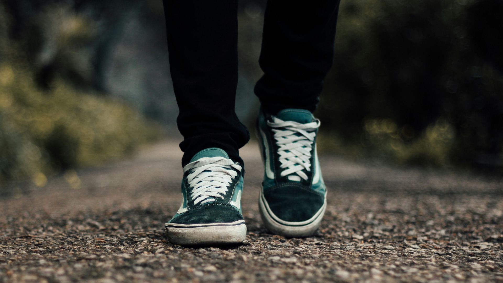 a person standing on a gravel road with their shoes on