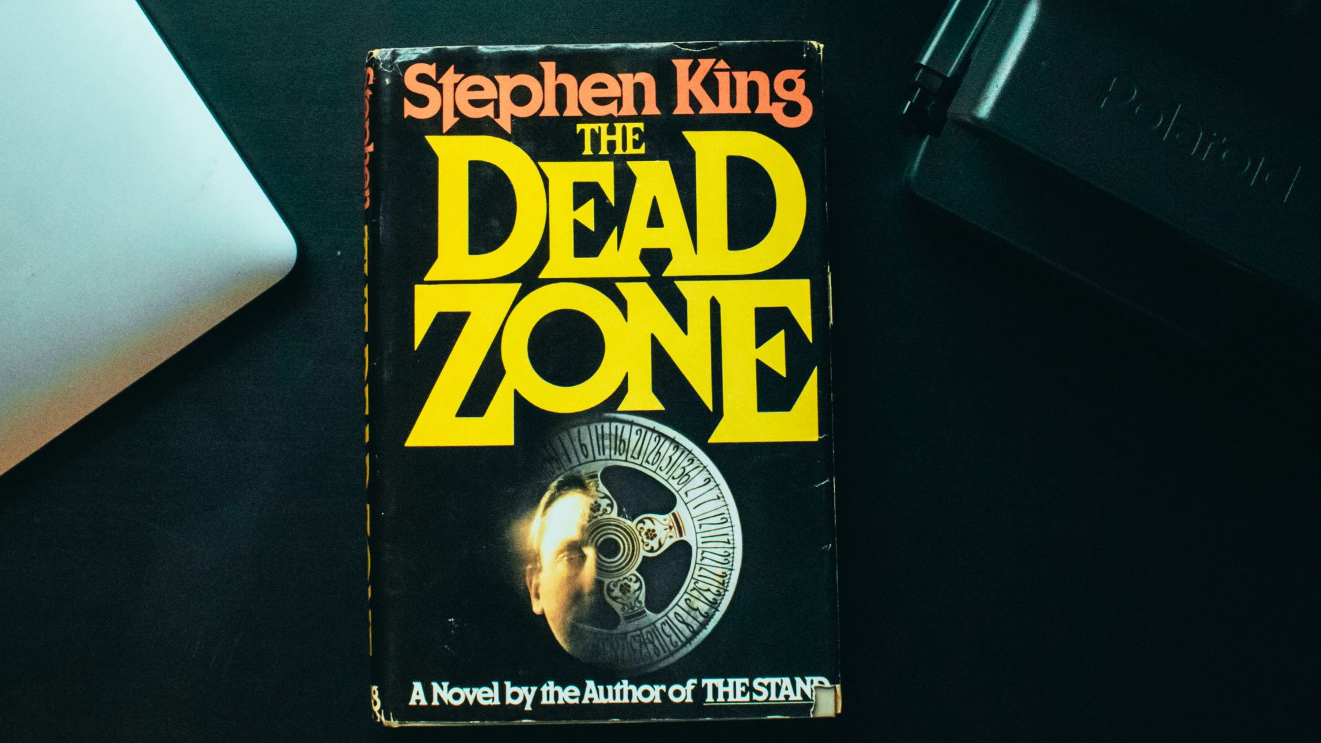 a book sitting on top of a desk next to a laptop