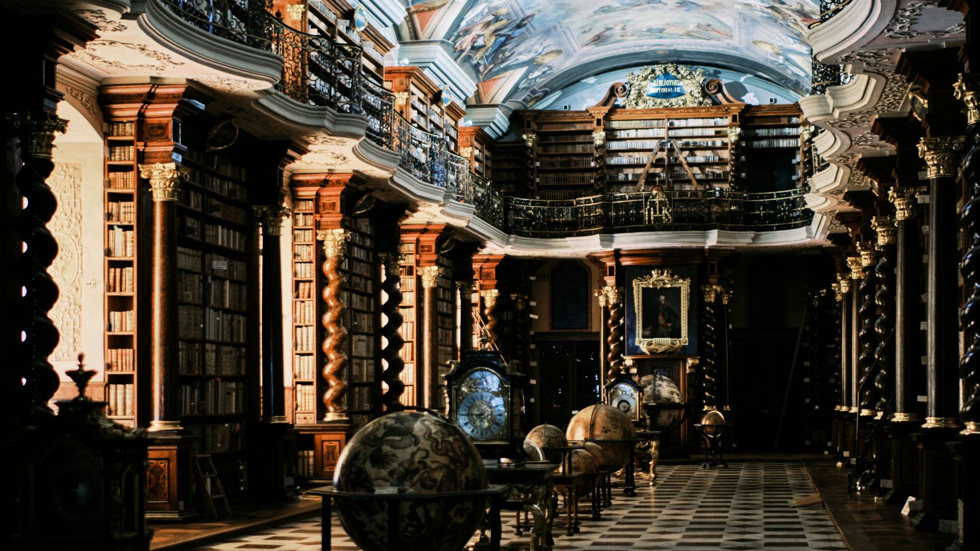 Grand library with bookshelves, globes, and a painted ceiling.