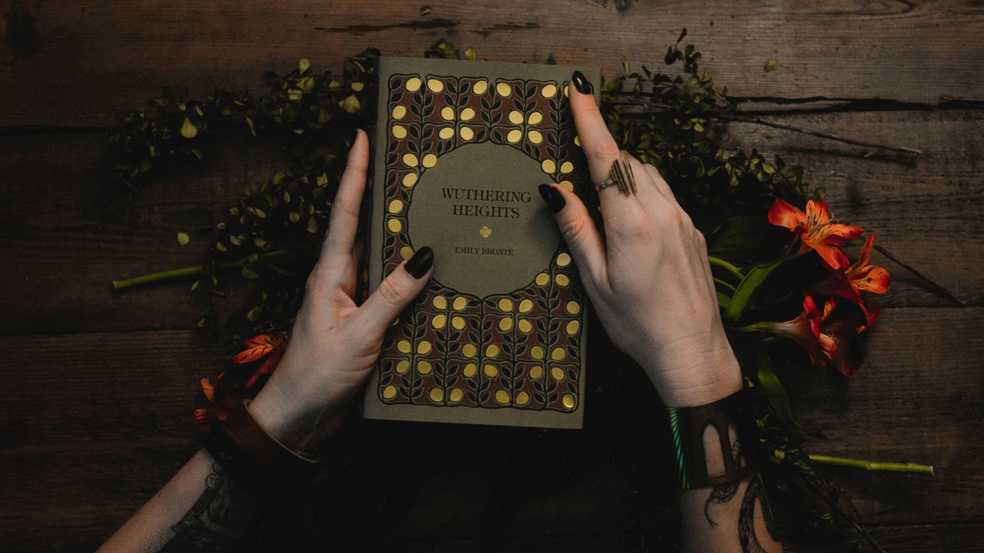 person holding black and gold book