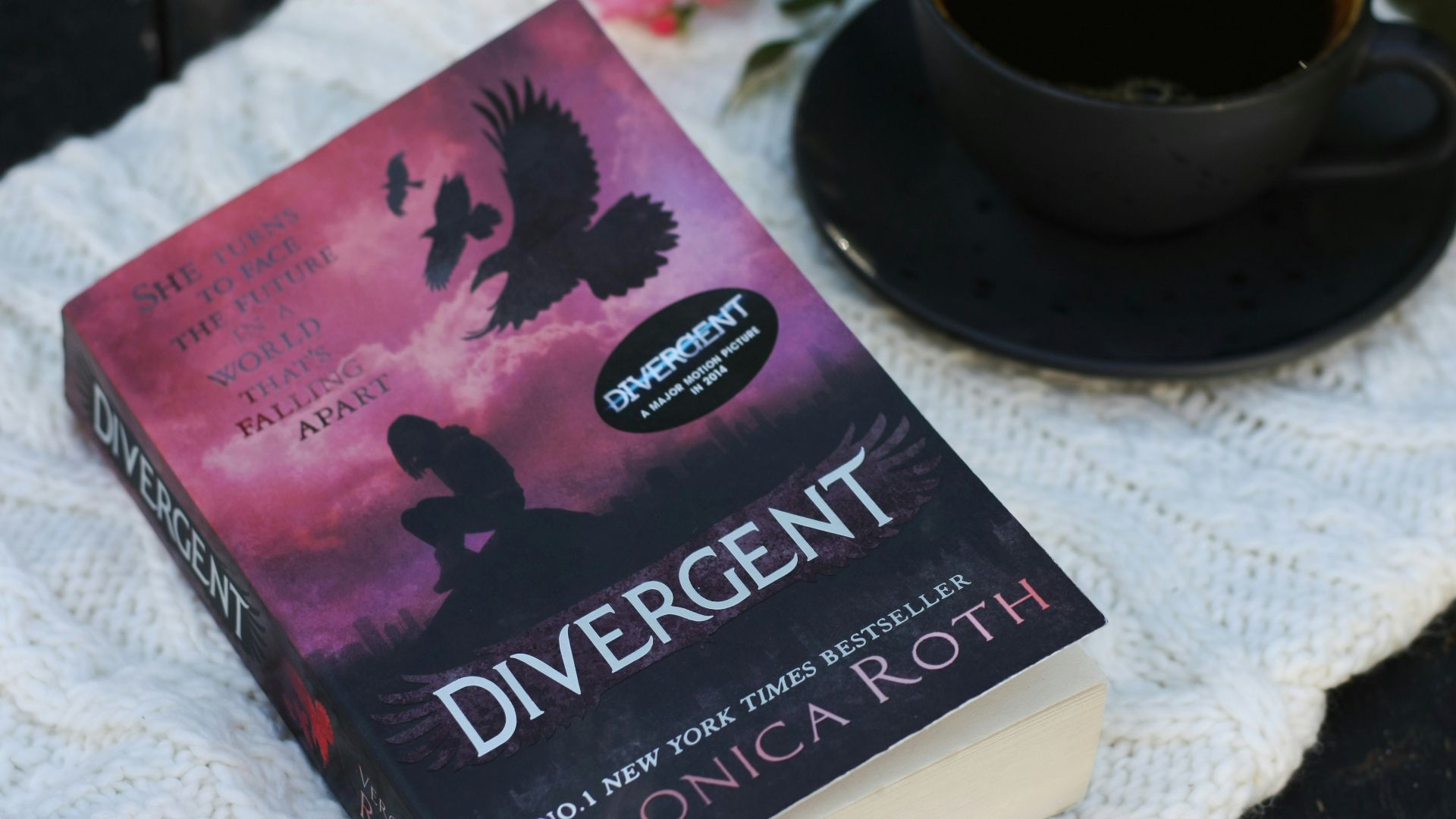 a book sitting on top of a table next to a cup of coffee