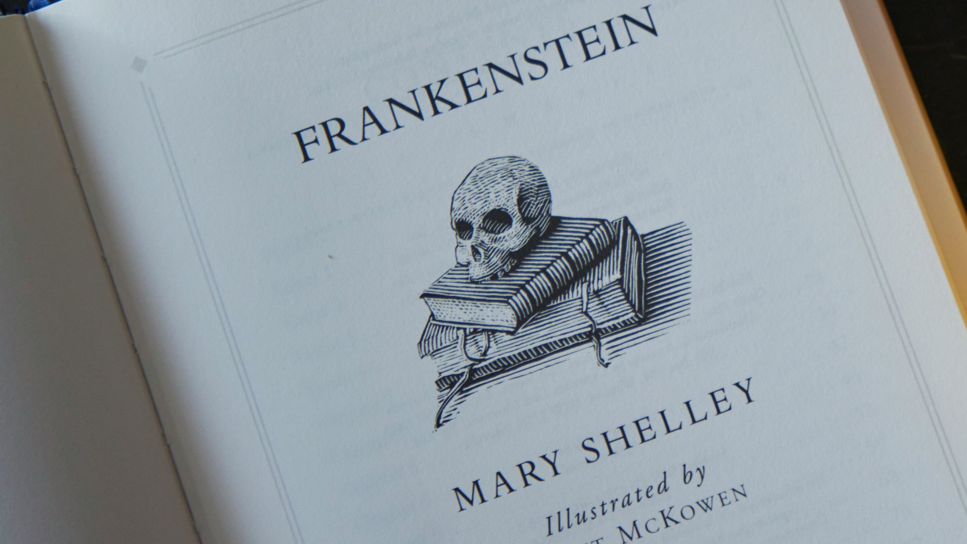 an open book sitting on top of a table next to two pumpkins