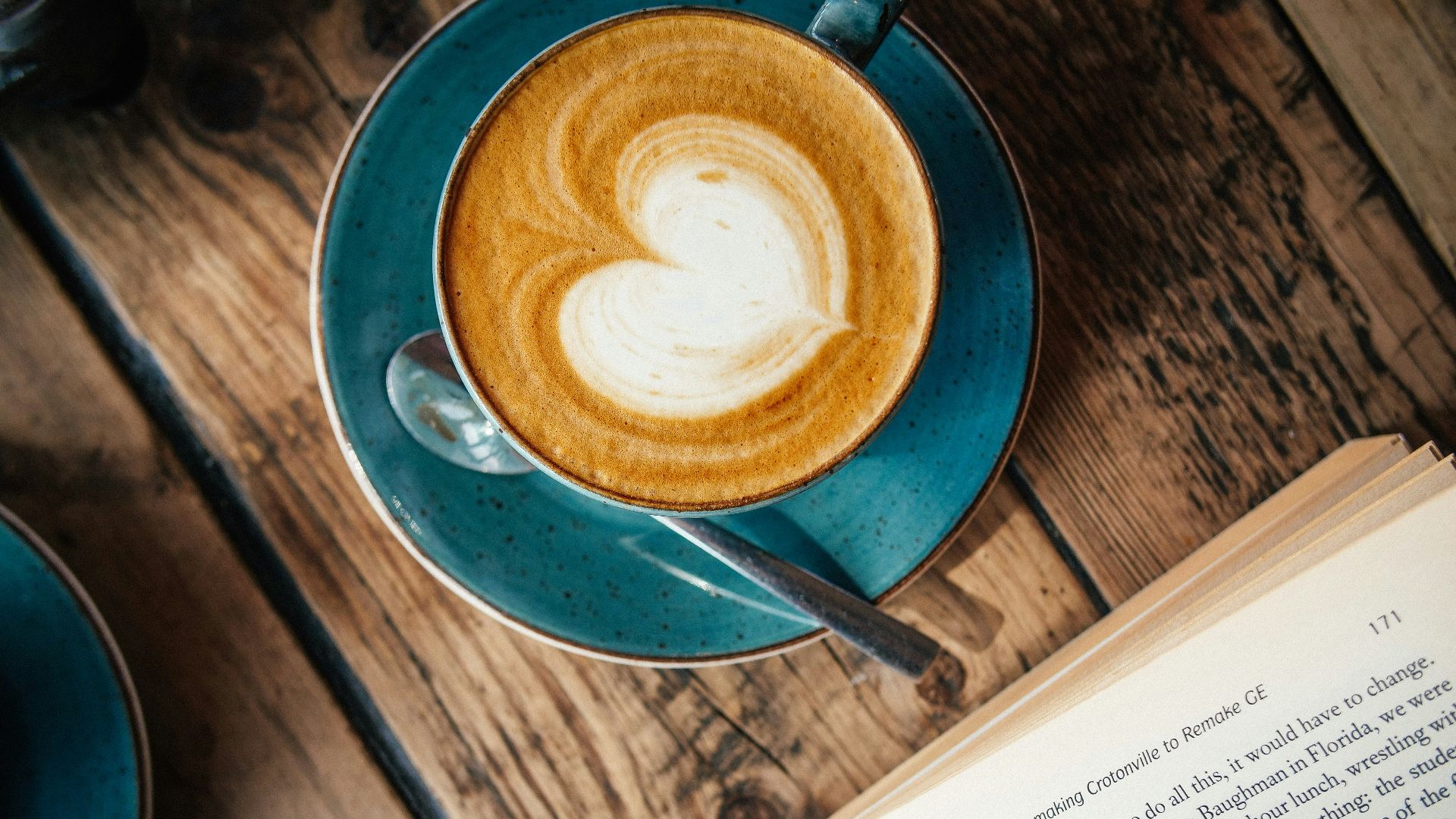 blue ceramic mug with cappuccino on blue saucer