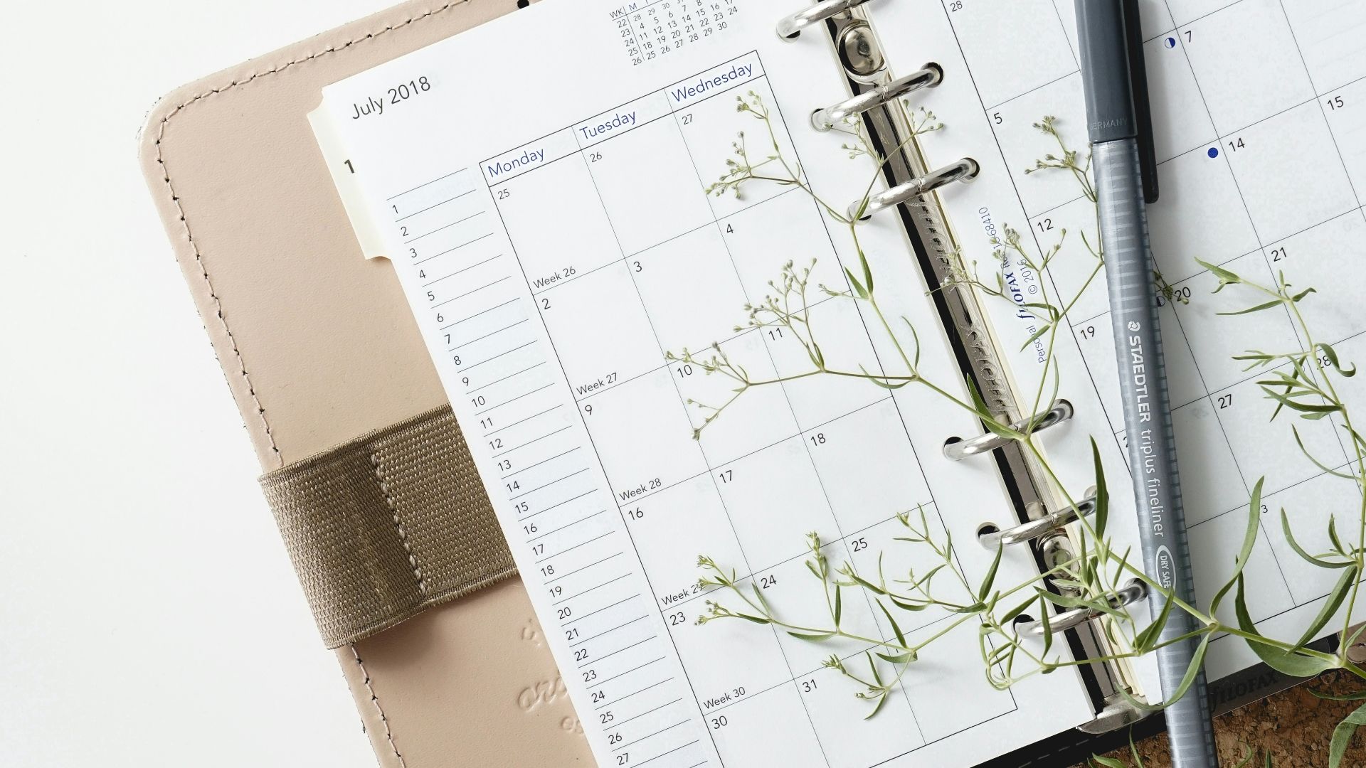 grey and black pen on calendar book
