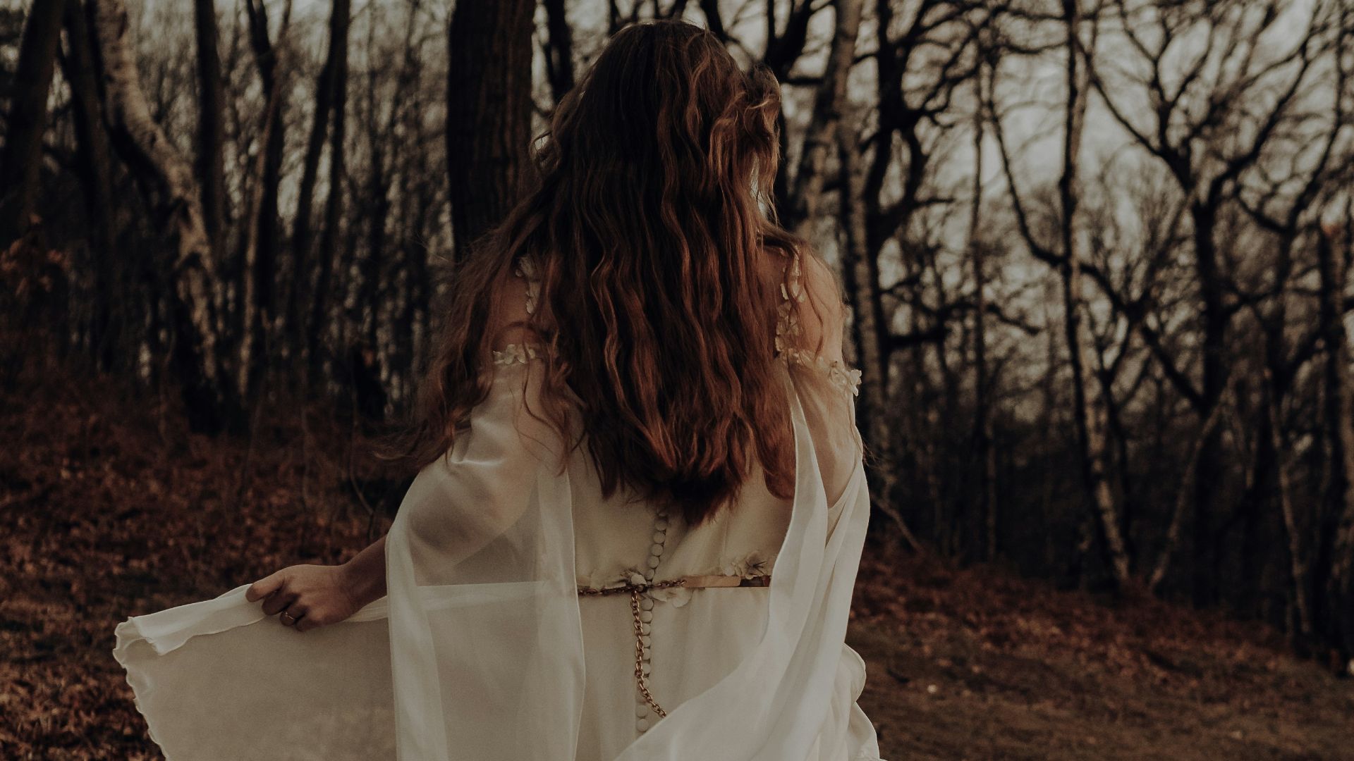 woman in white dress standing on brown soil