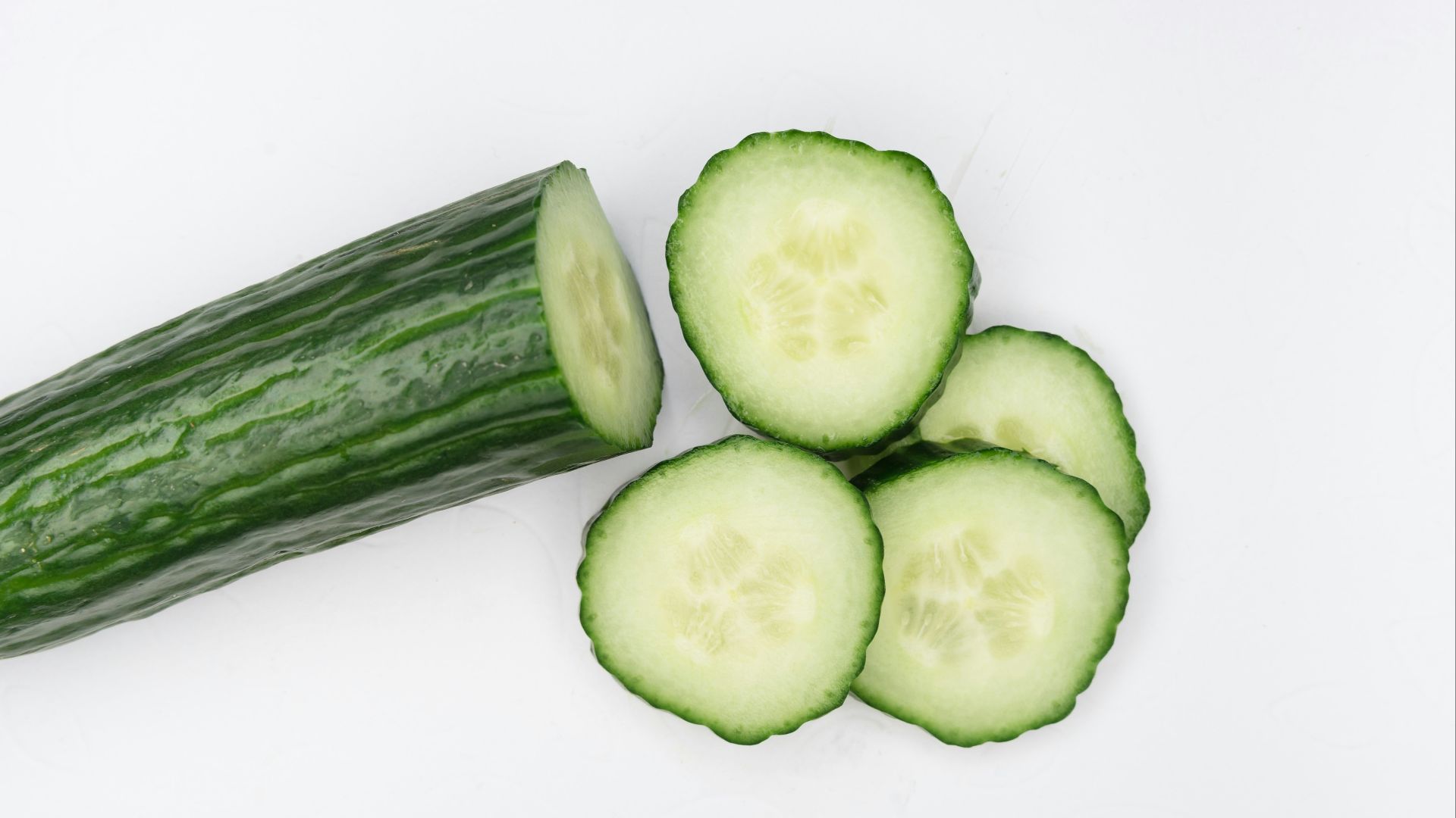 sliced cucumber on white surface