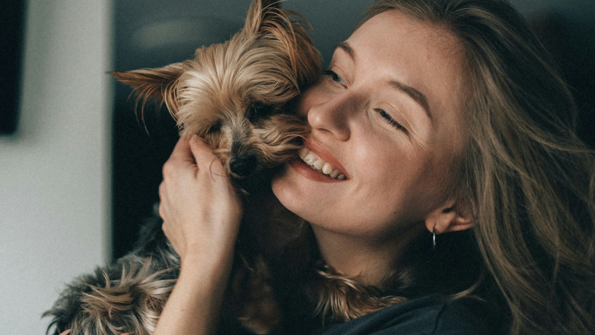 a woman holding a small dog in her arms
