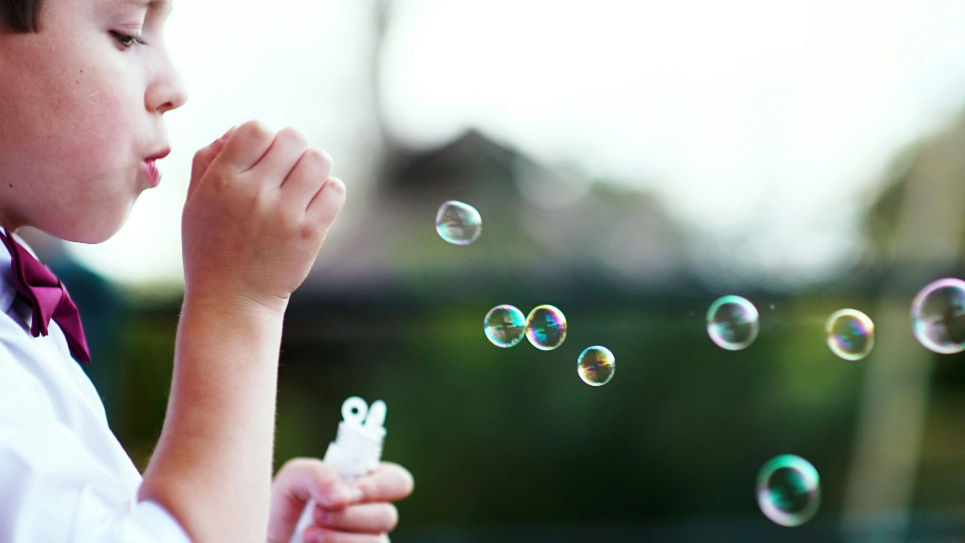selective photography of boy playing with bubbles