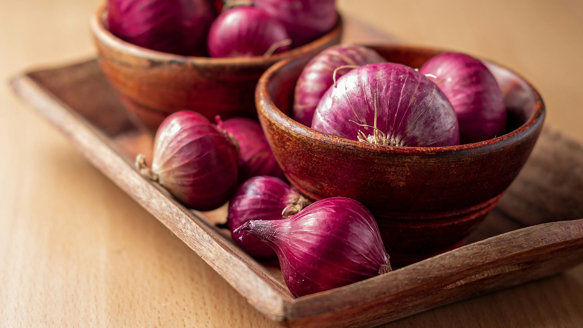 red onion on brown wooden tray