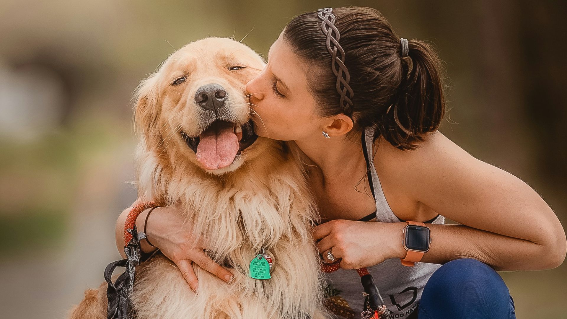 a woman kissing her dog on the cheek