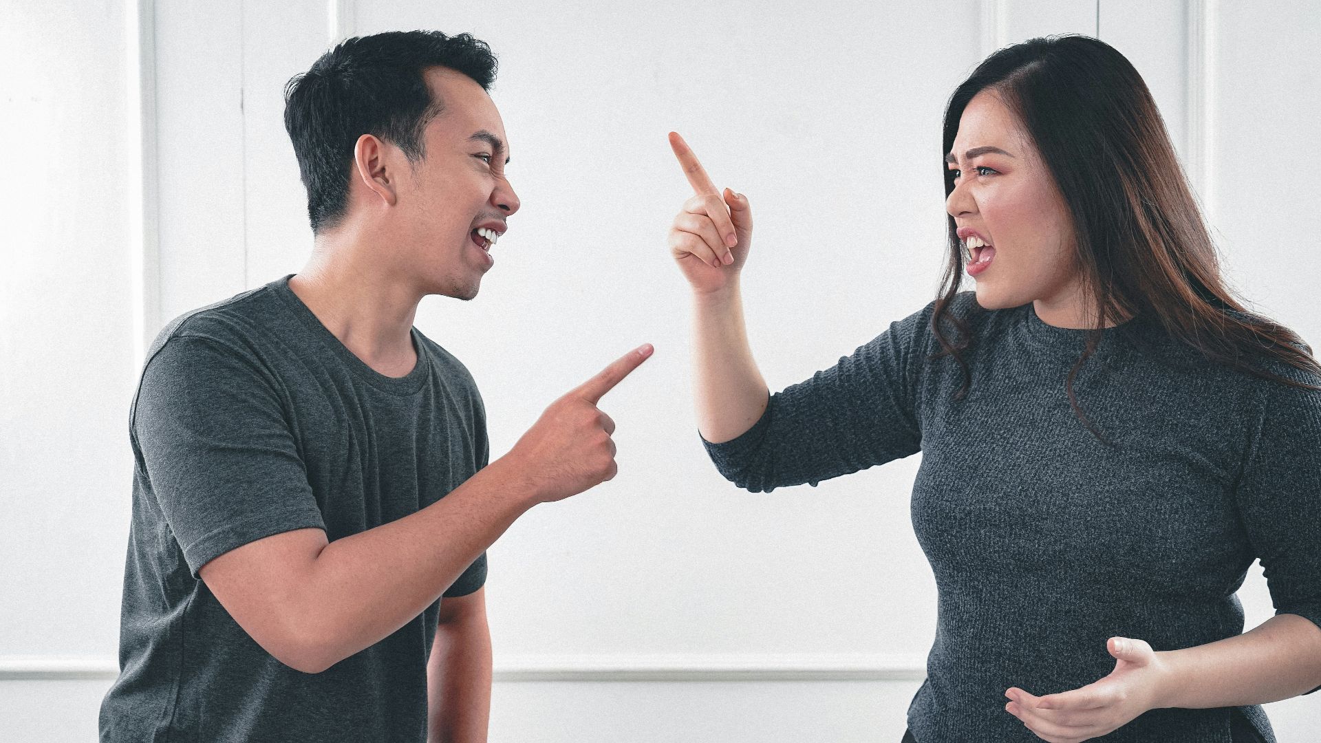 man in gray crew neck long sleeve shirt standing beside woman in black crew neck shirt