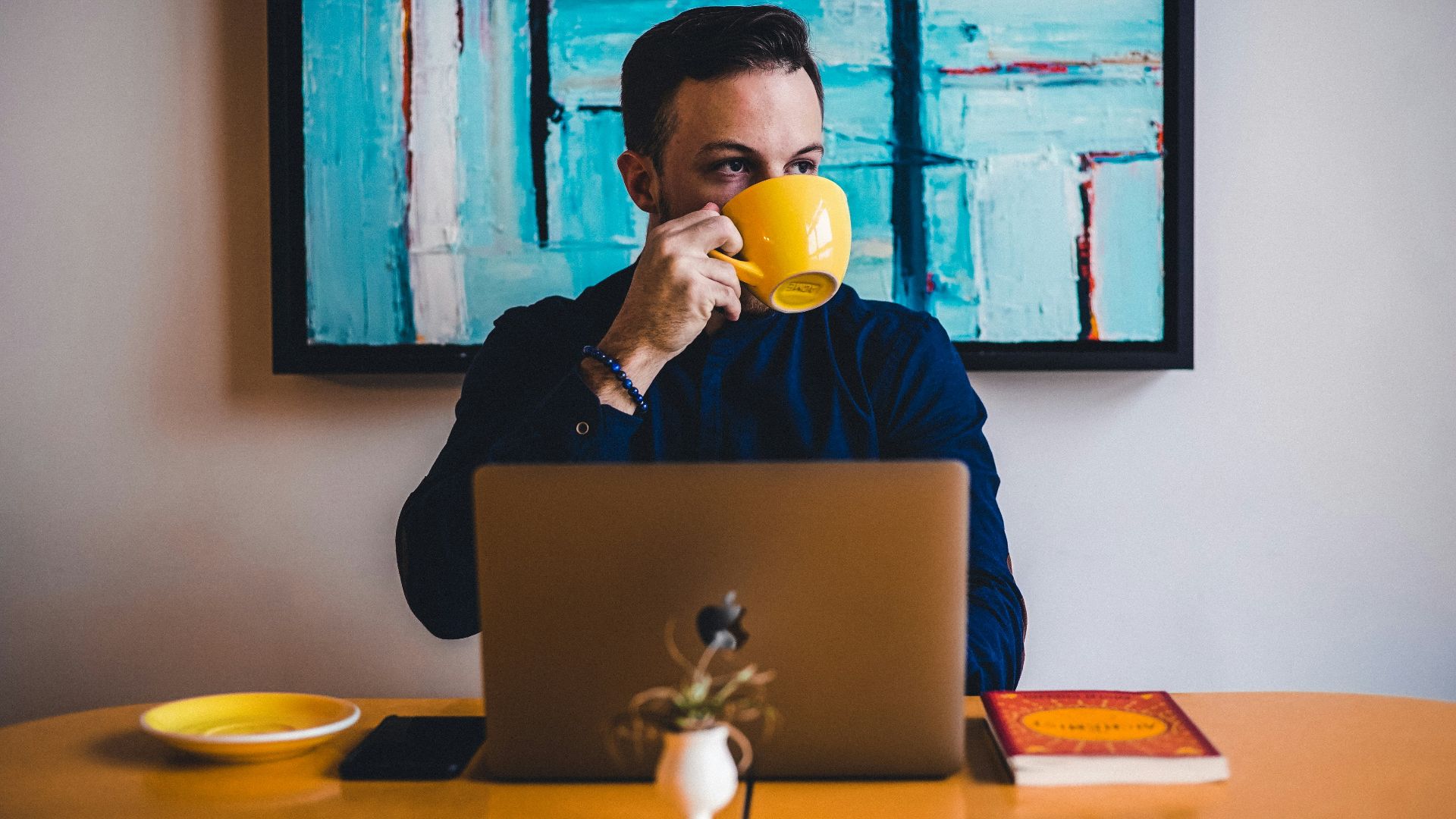 man drinking coffee in front of the laptop computer