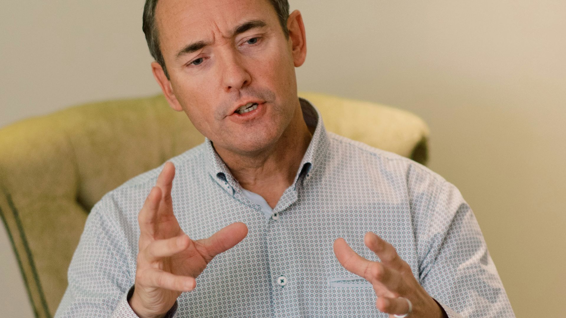 man in blue dress shirt sitting on yellow chair