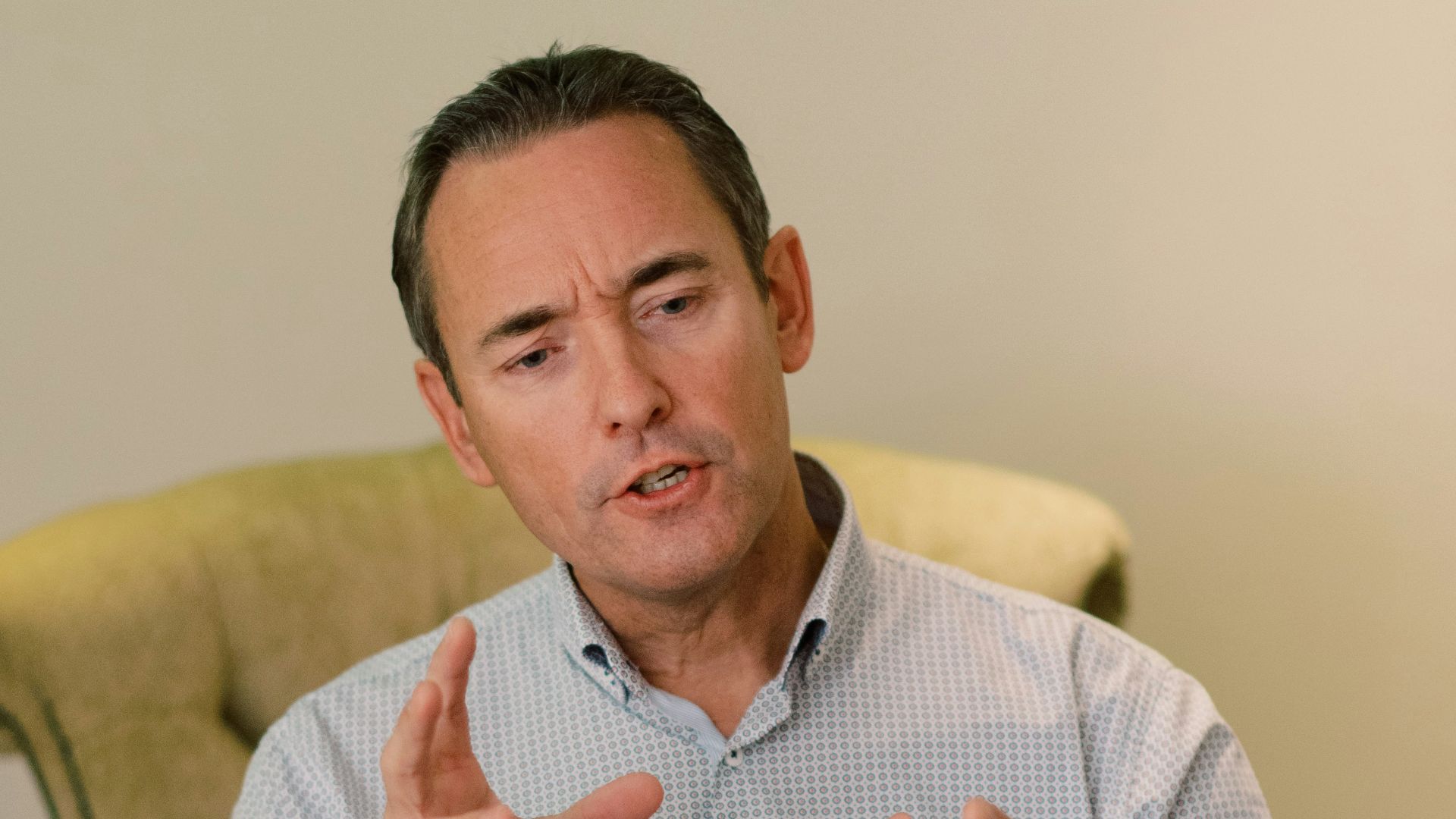 man in blue dress shirt sitting on yellow chair