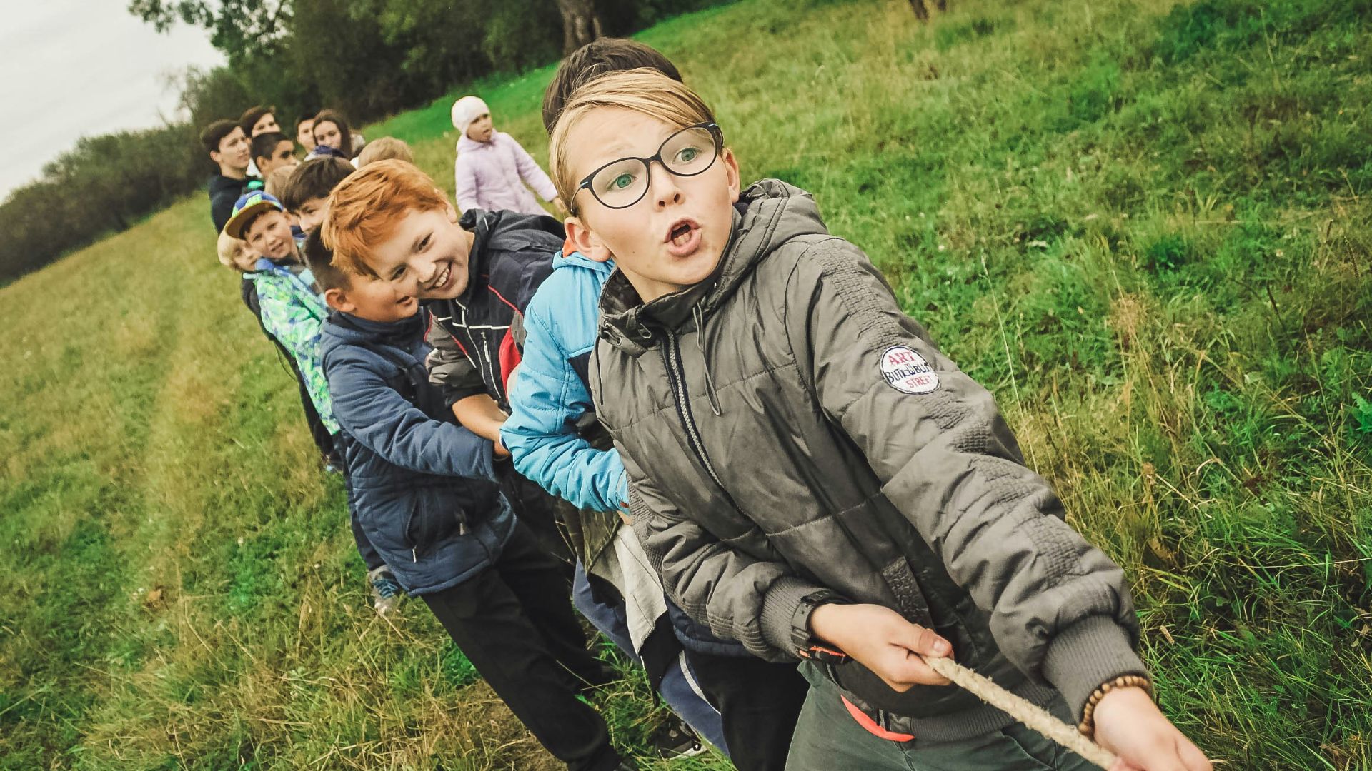 group of children pulling brown rope