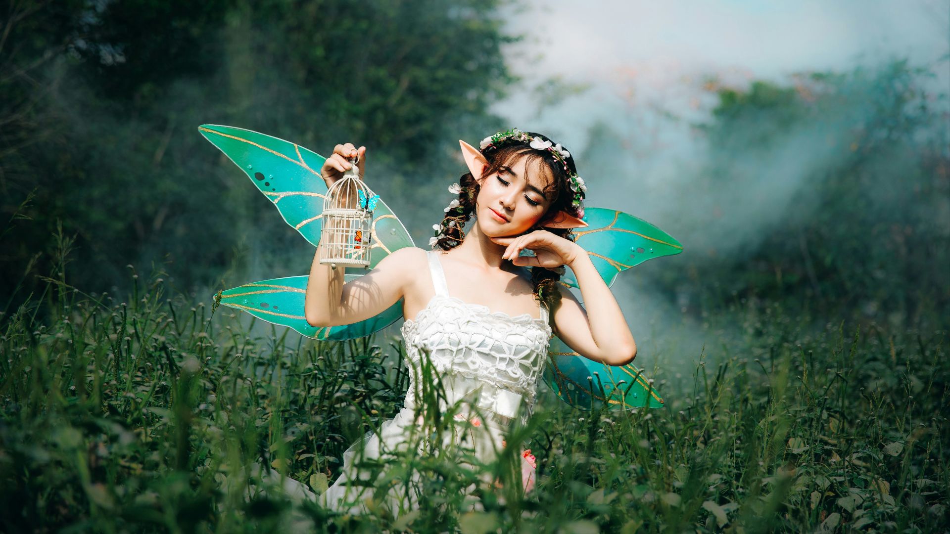 woman in white dress wearing green fairy wings