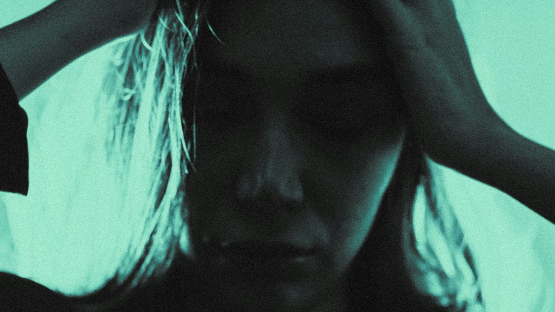 a woman holding her hair in the dark