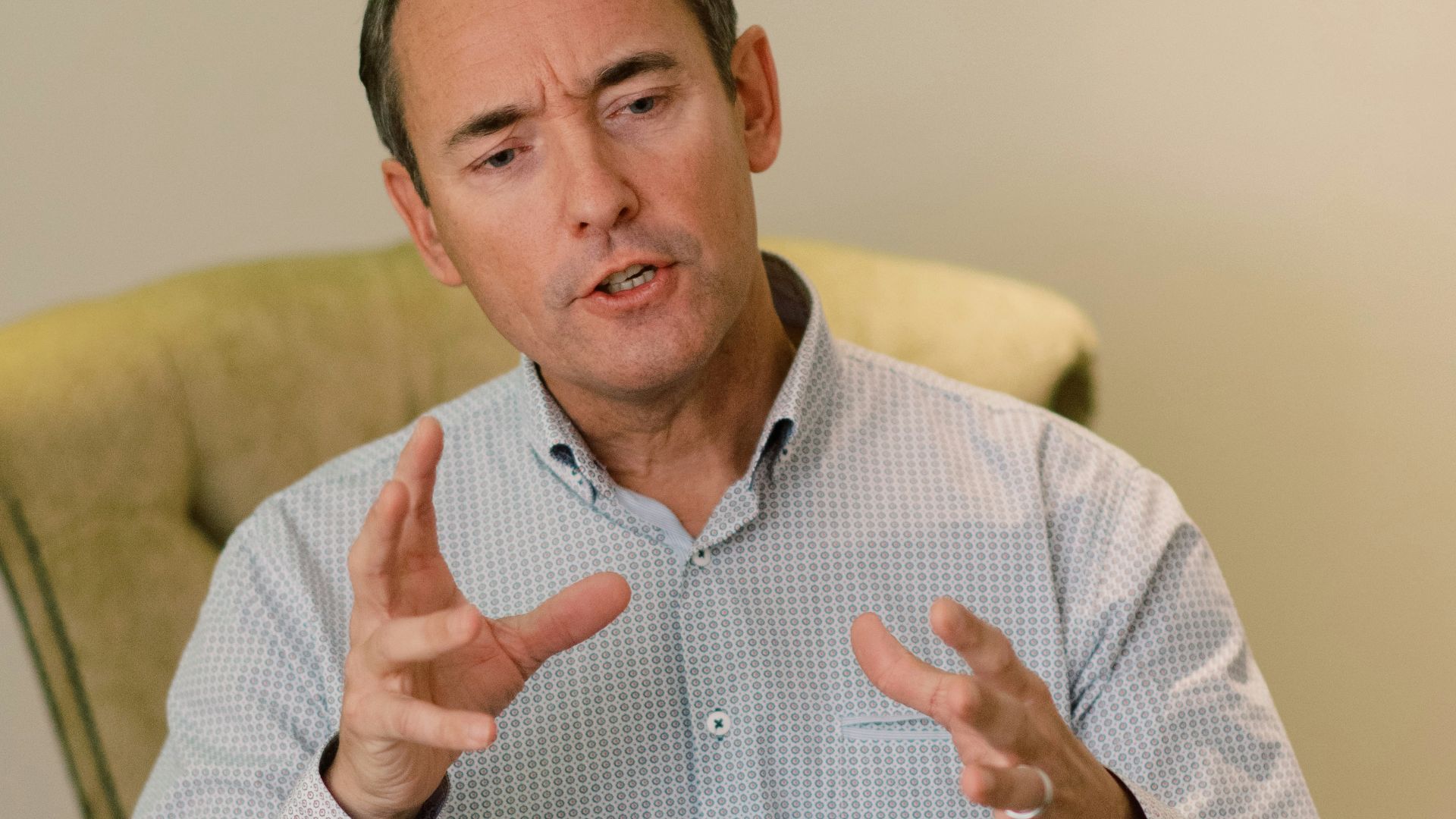 man in blue dress shirt sitting on yellow chair