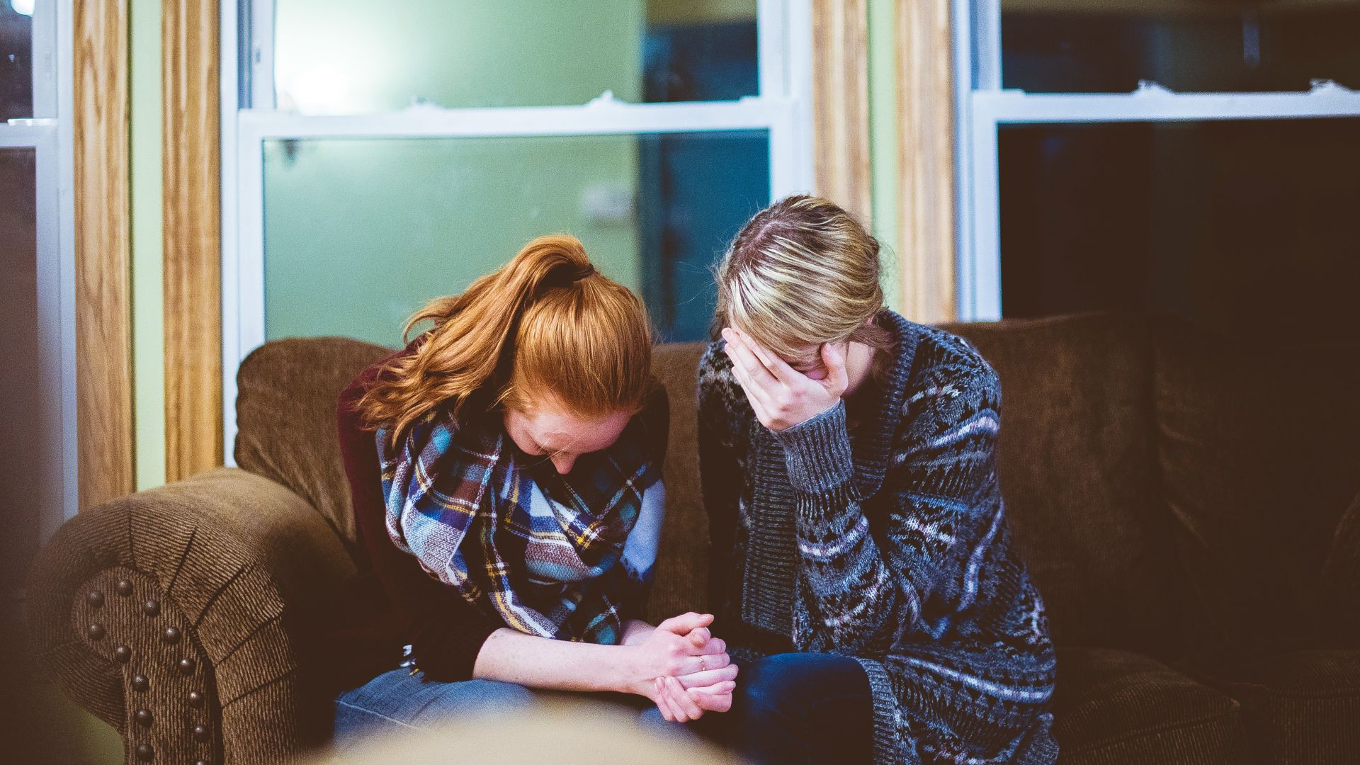 man and woman sitting on sofa in a room