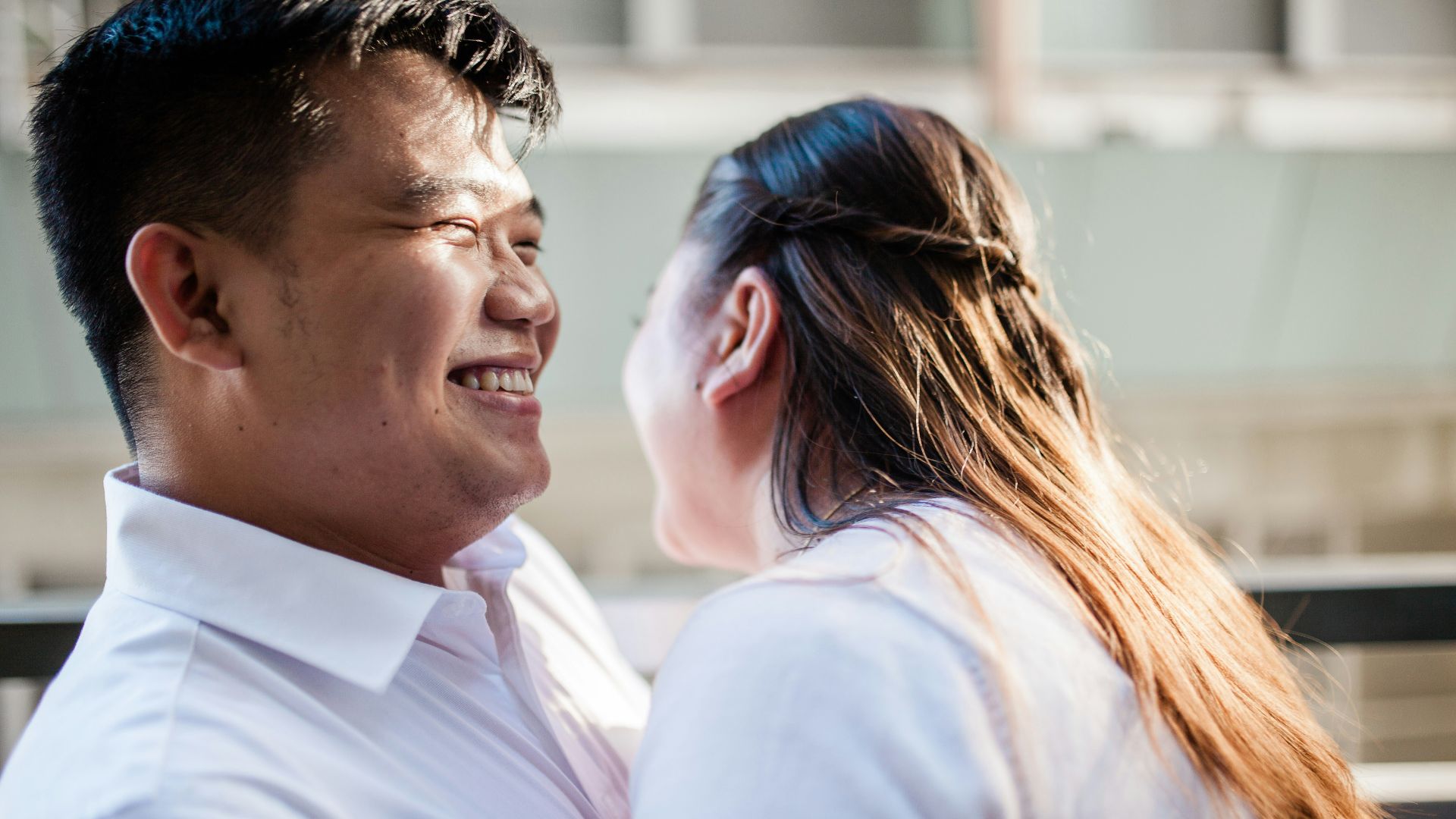 man in white polo shirt kissing woman in white shirt