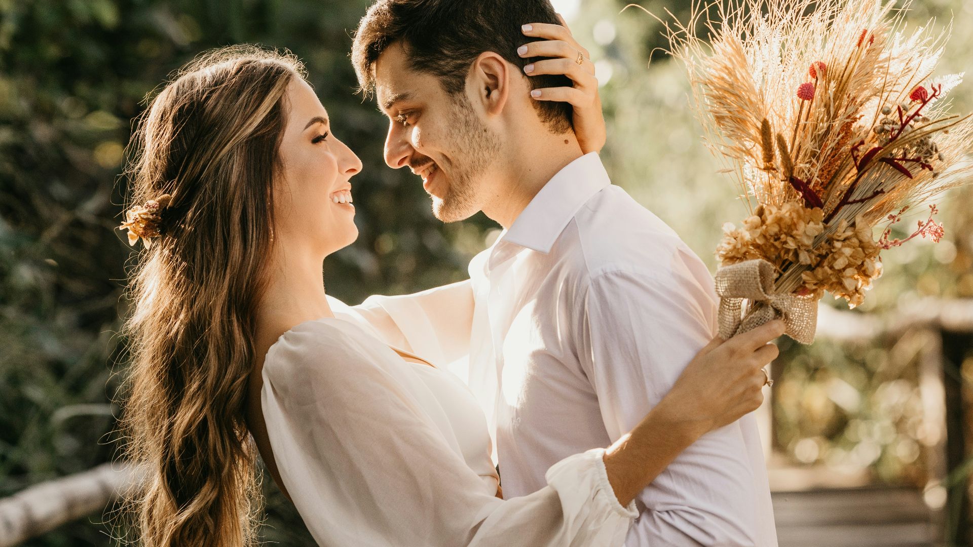 man in white dress shirt holding brown flower bouquet