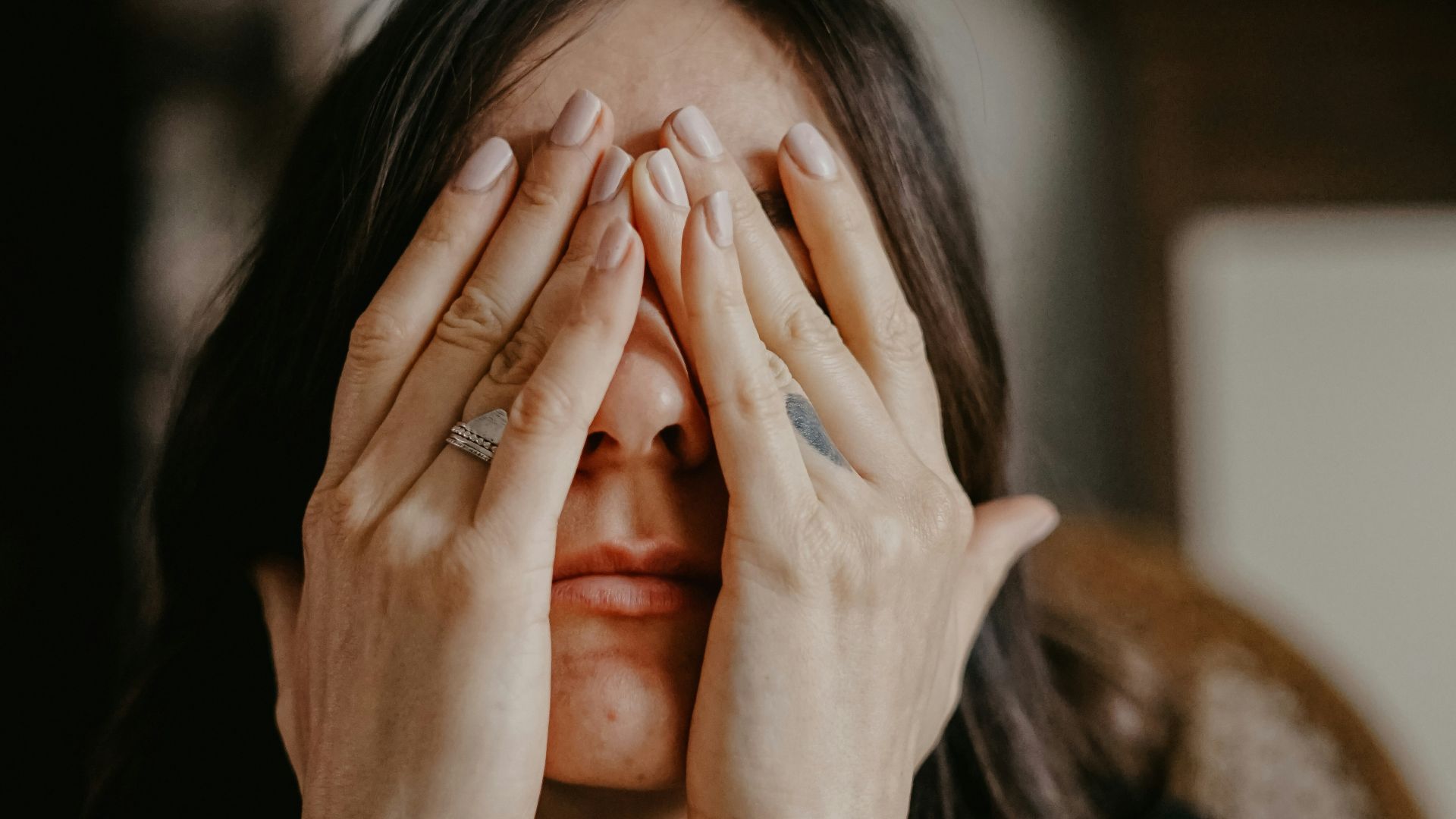 woman in black long sleeve shirt covering her face