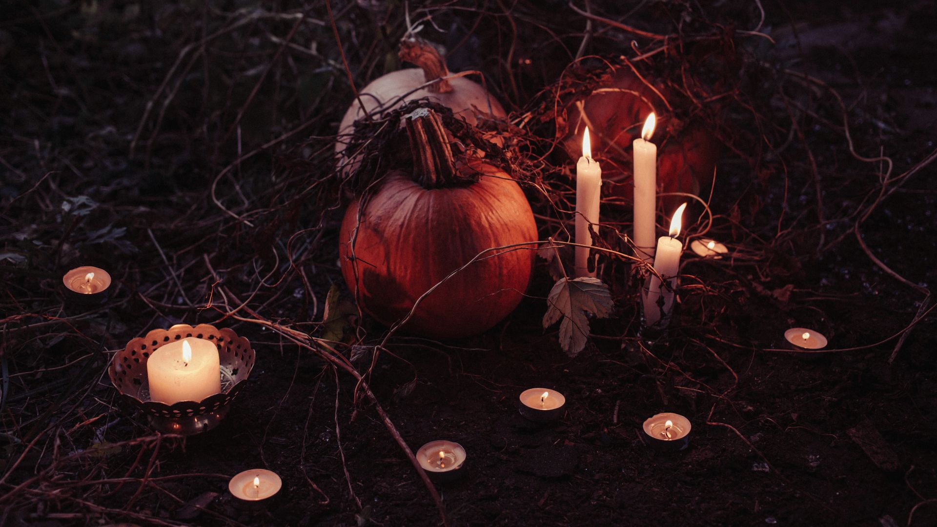 pumpkin between lighted candles