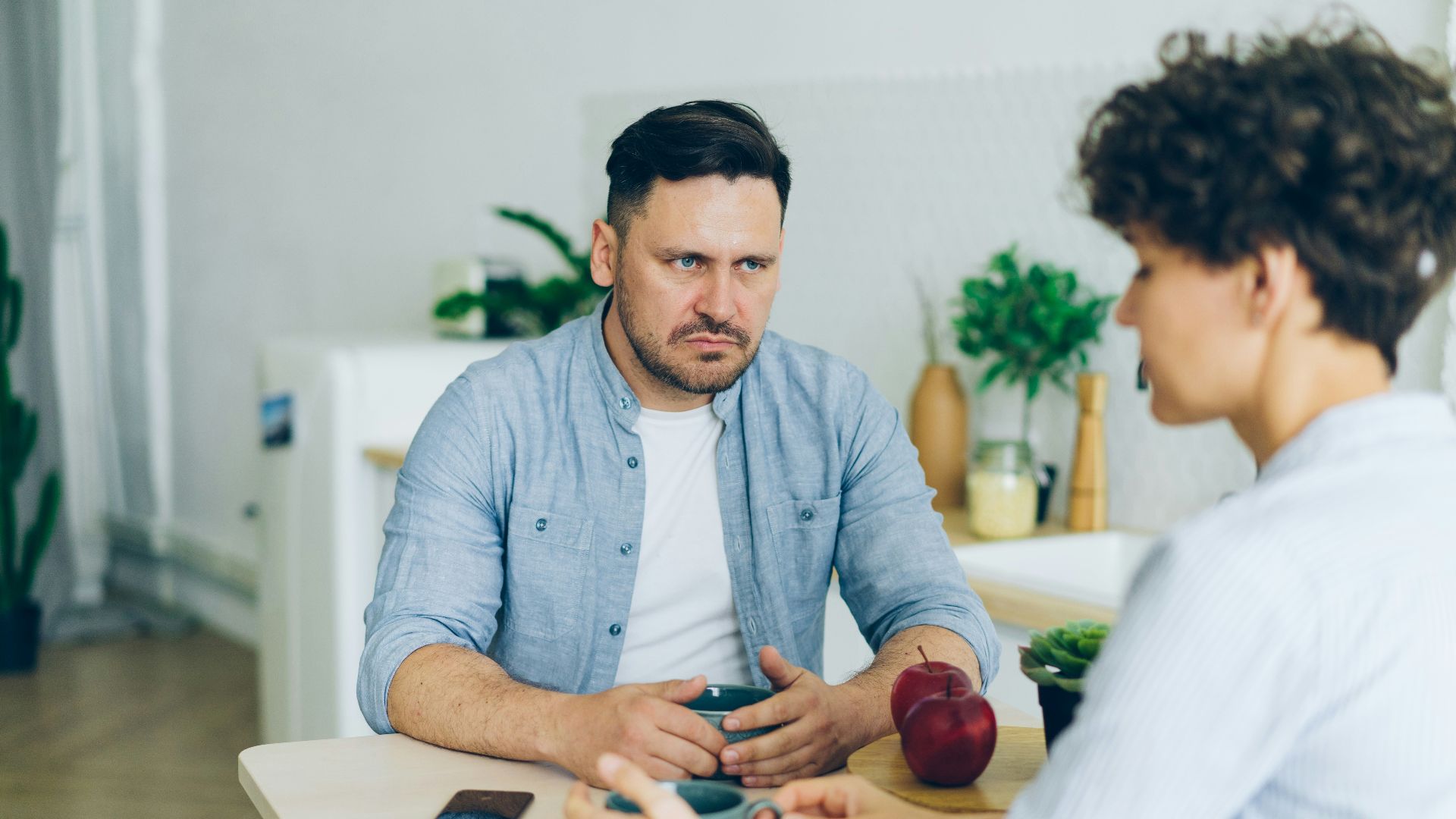 a man sitting at a table talking to a woman