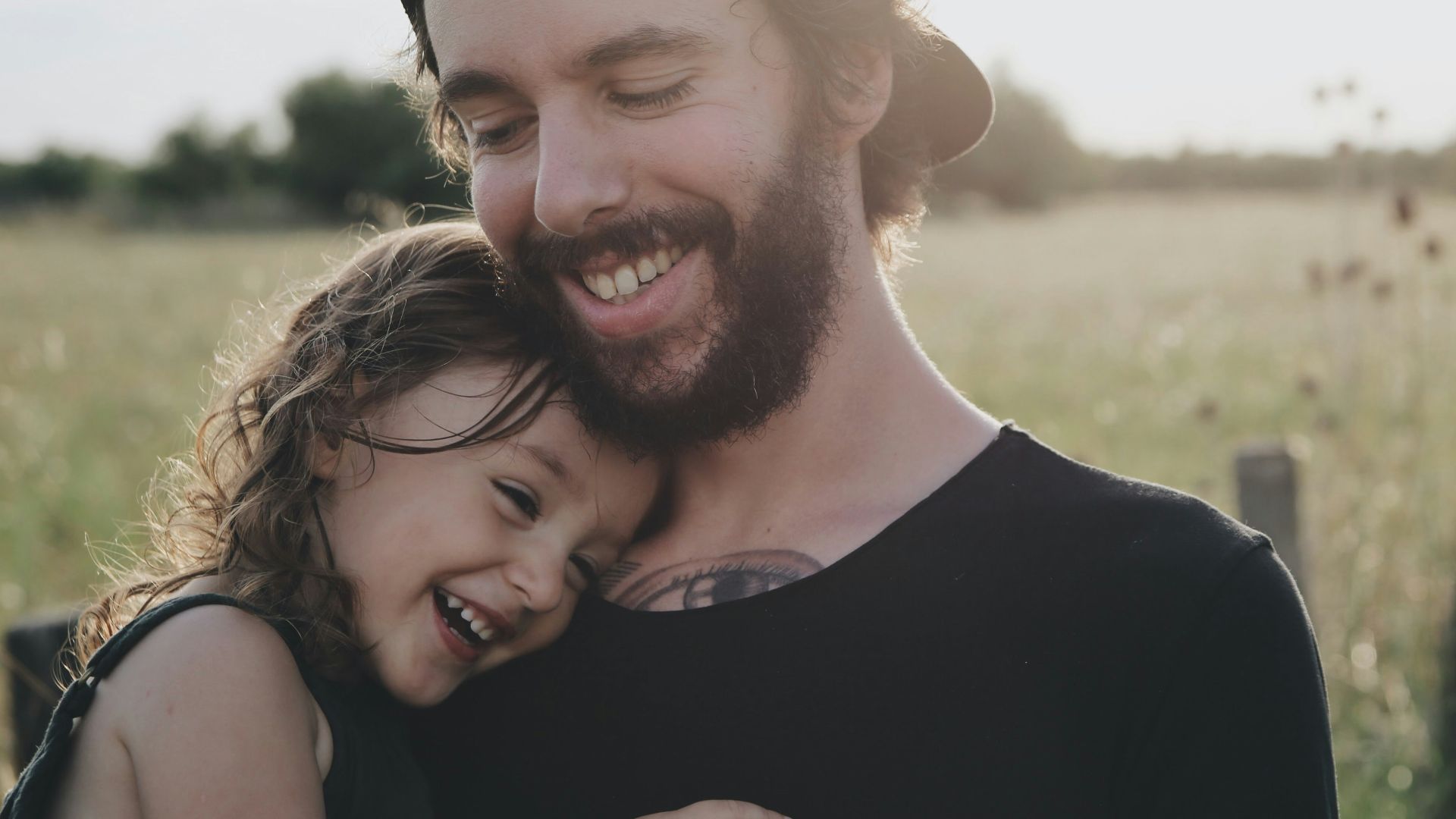 man carrying daughter in black sleeveless top