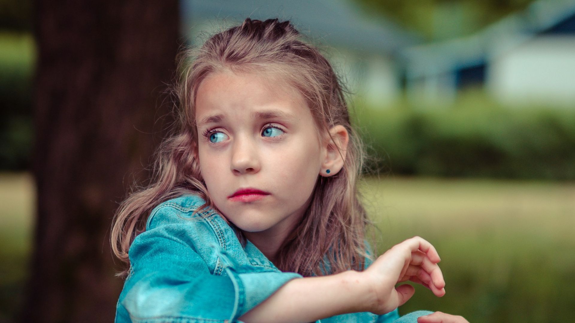 selective focus photography of girl sitting near tree