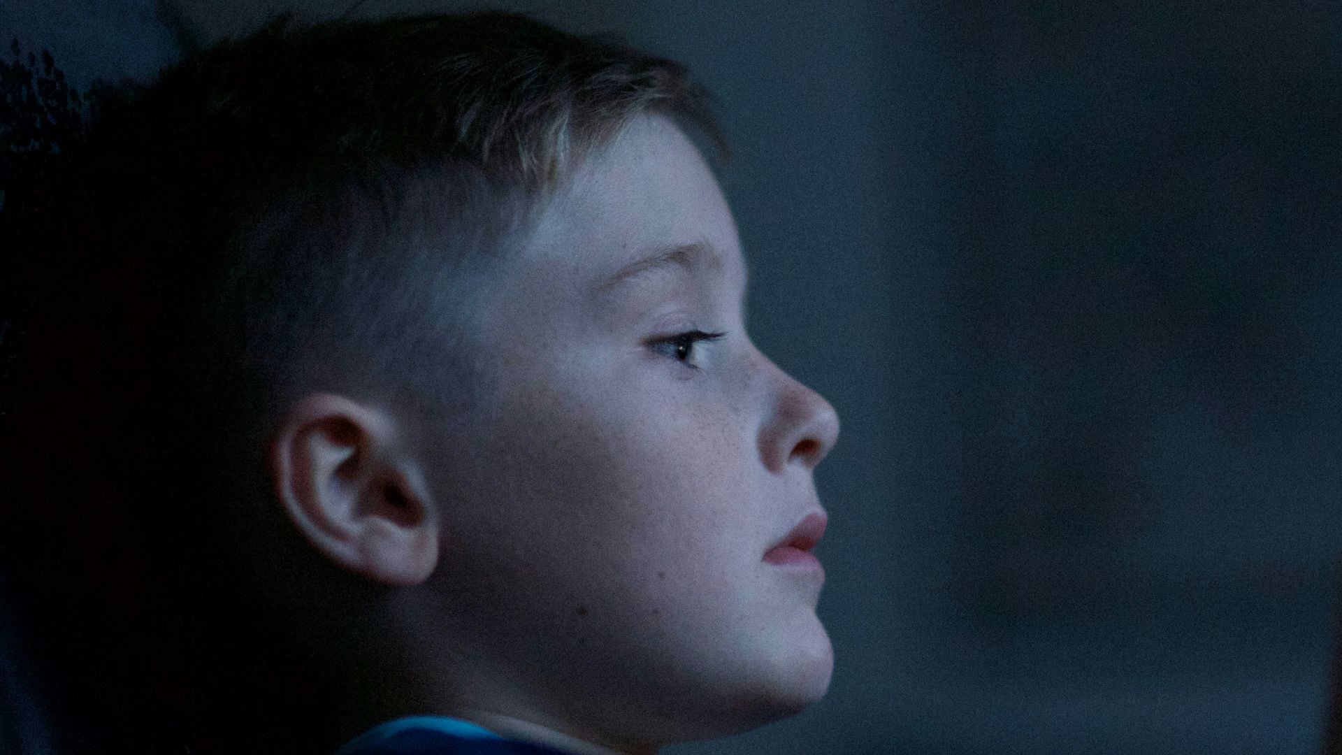 boy leaning on black wall