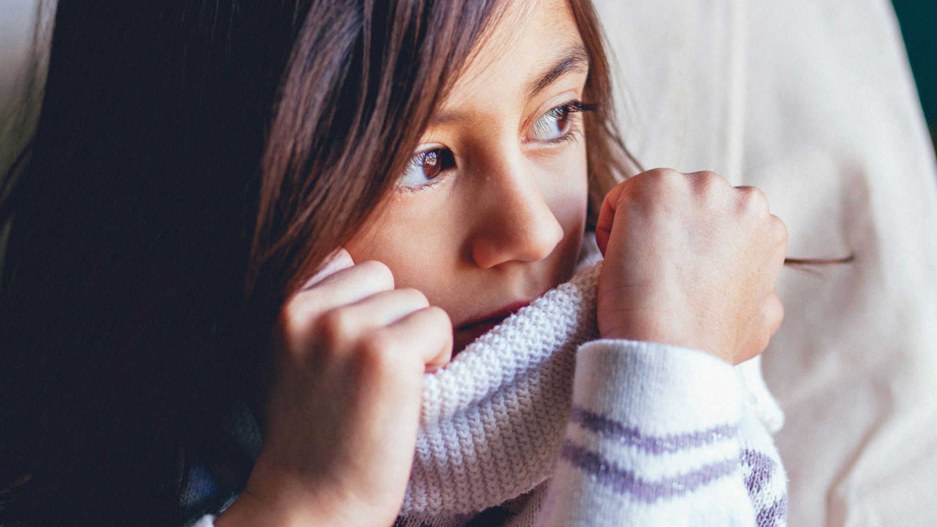 girl sitting on vehicle seat while looking at window