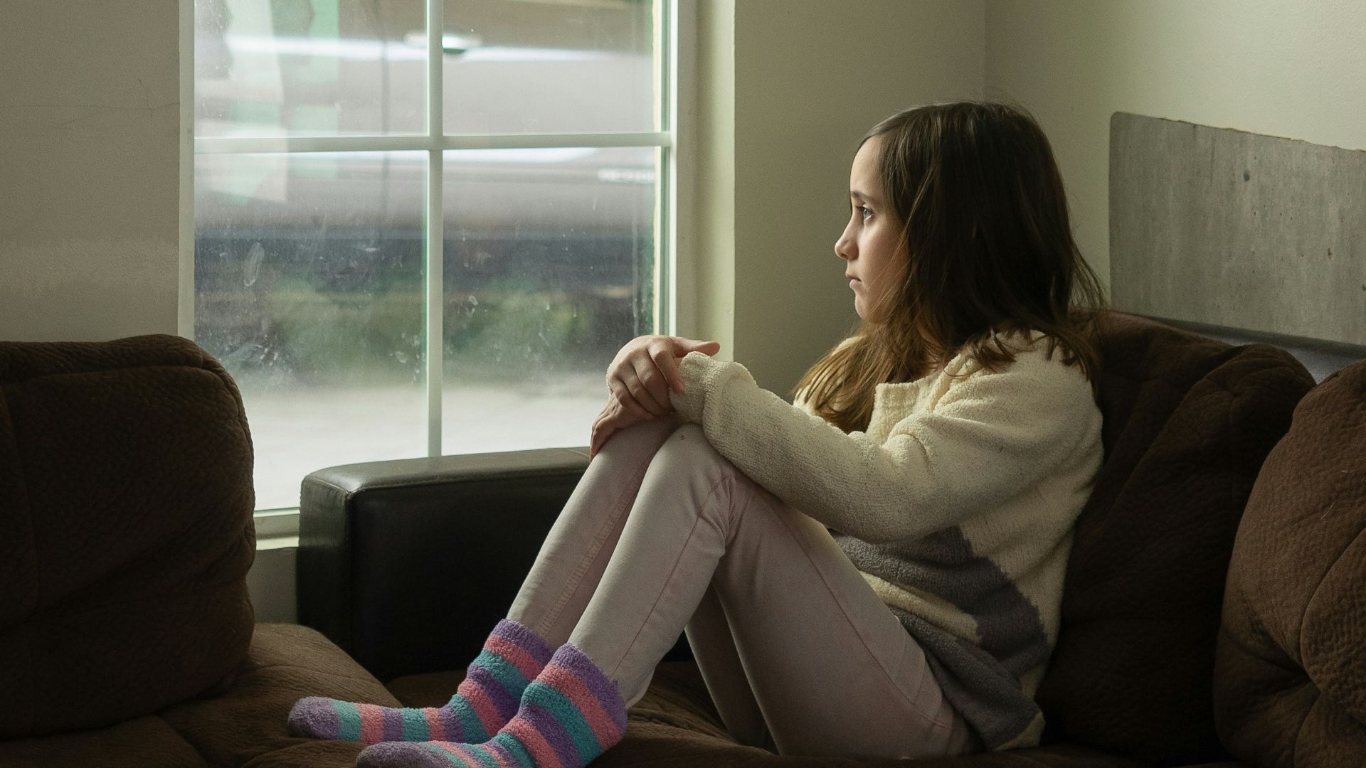 woman in white long sleeve shirt sitting on black couch