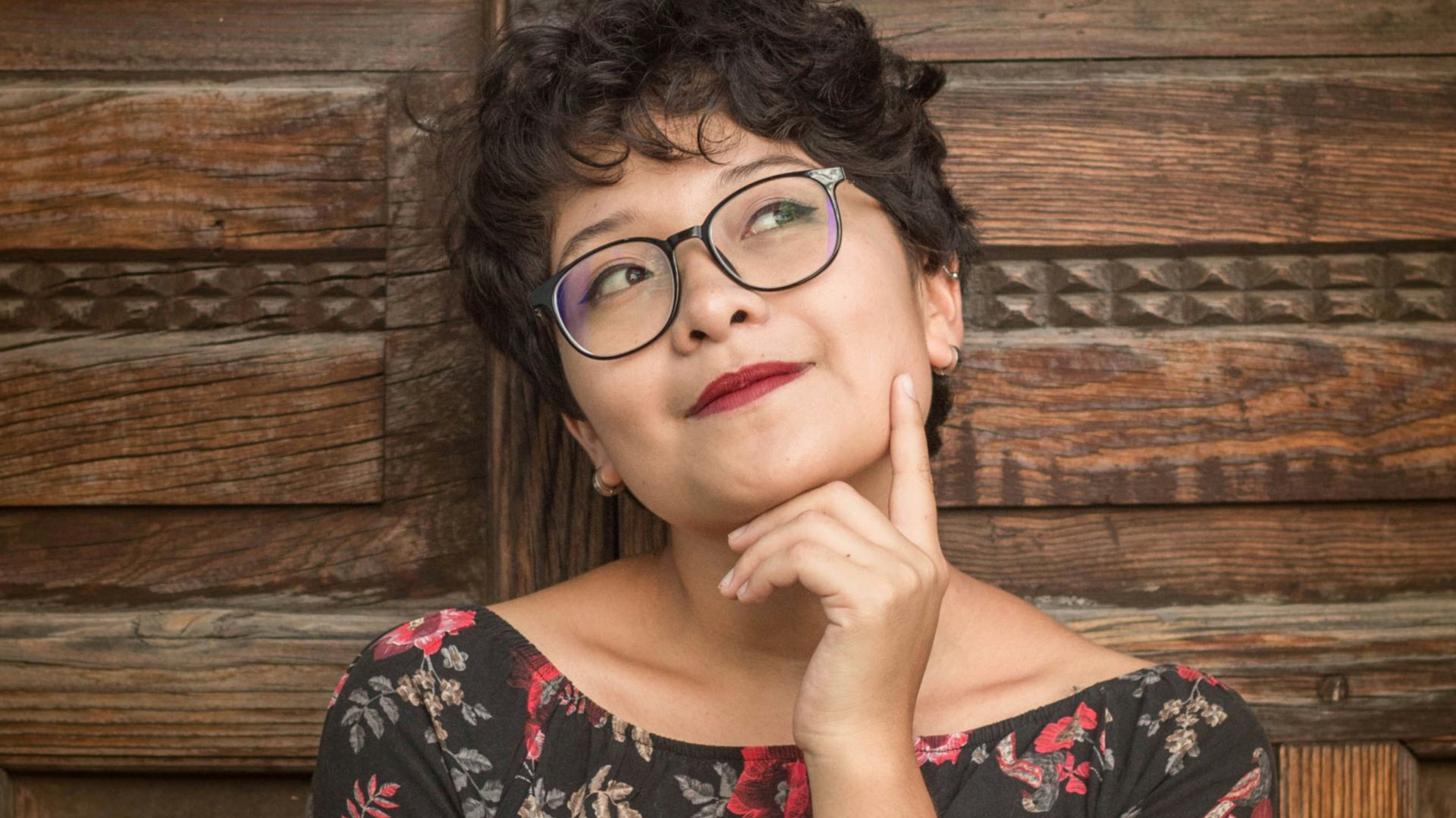 woman leaning against door while holding her cheek