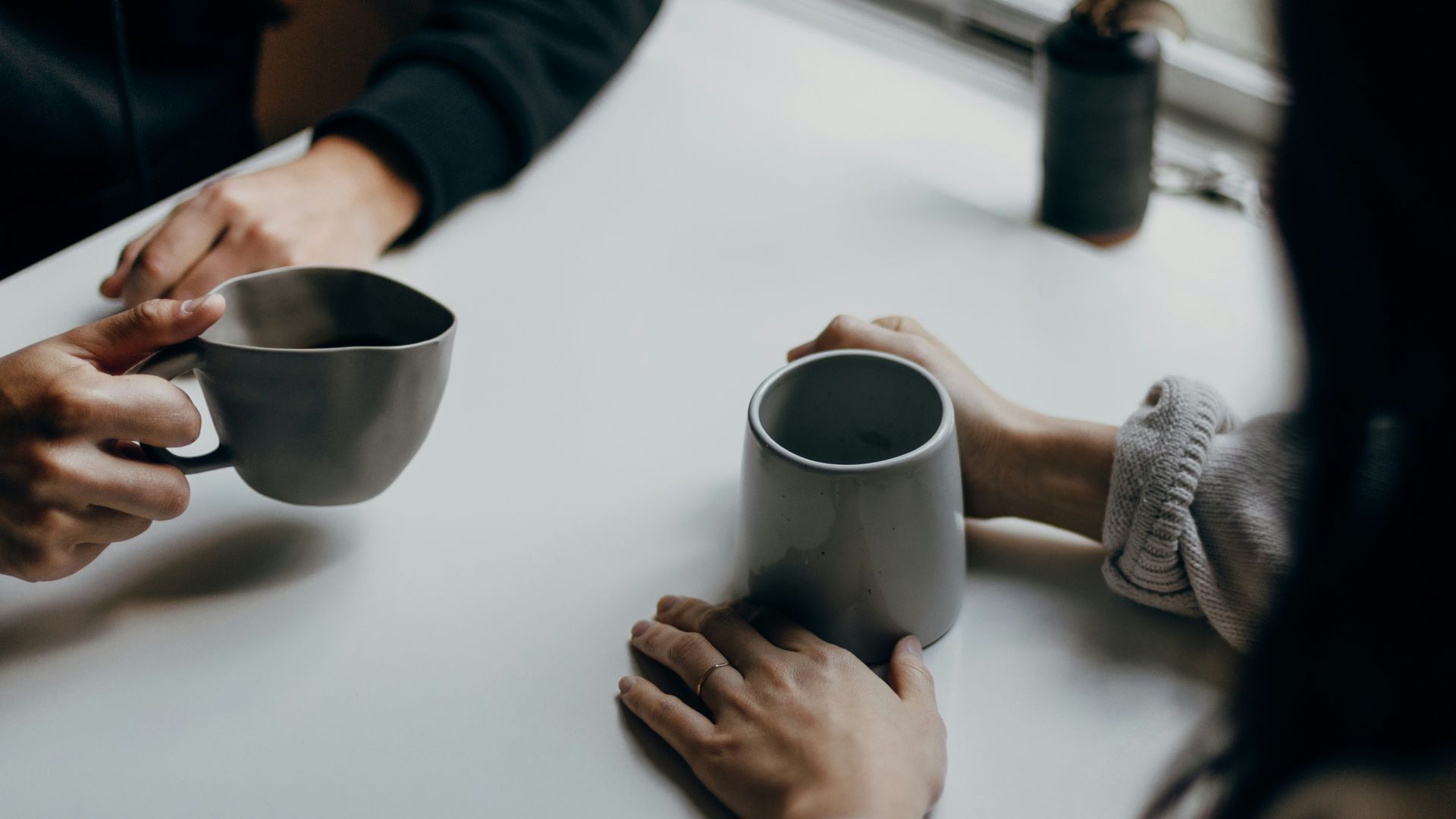 woman in black long sleeve shirt holding black ceramic mug