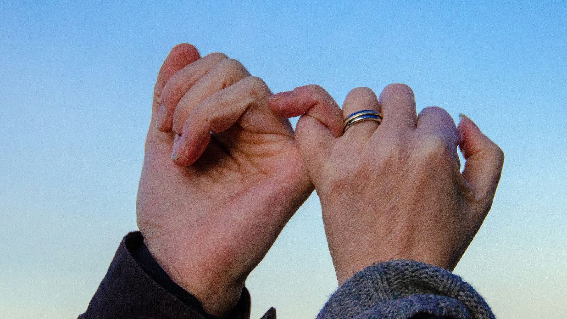 person in gray sweater with silver ring