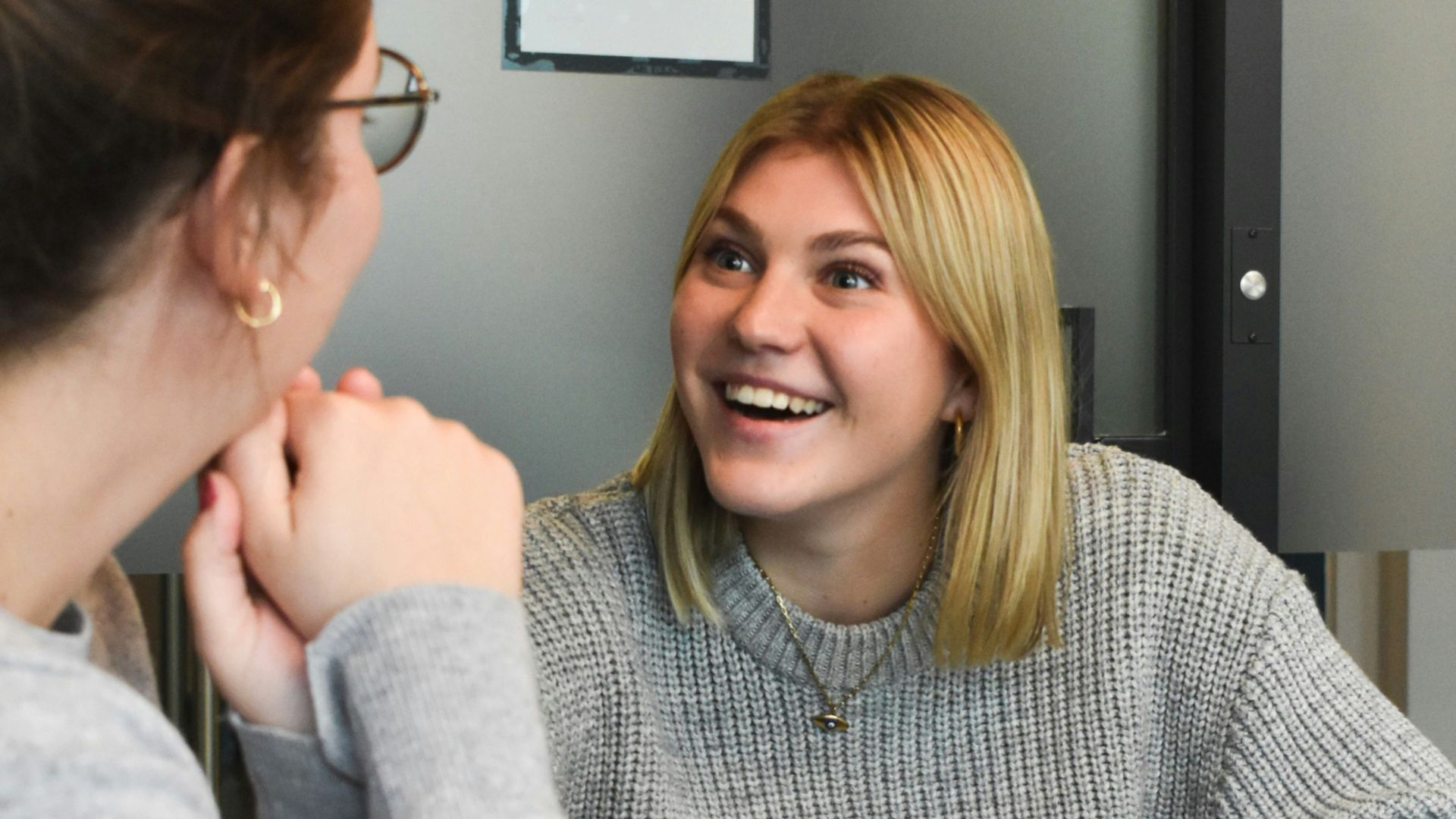 woman in gray sweater sitting beside woman in gray sweater