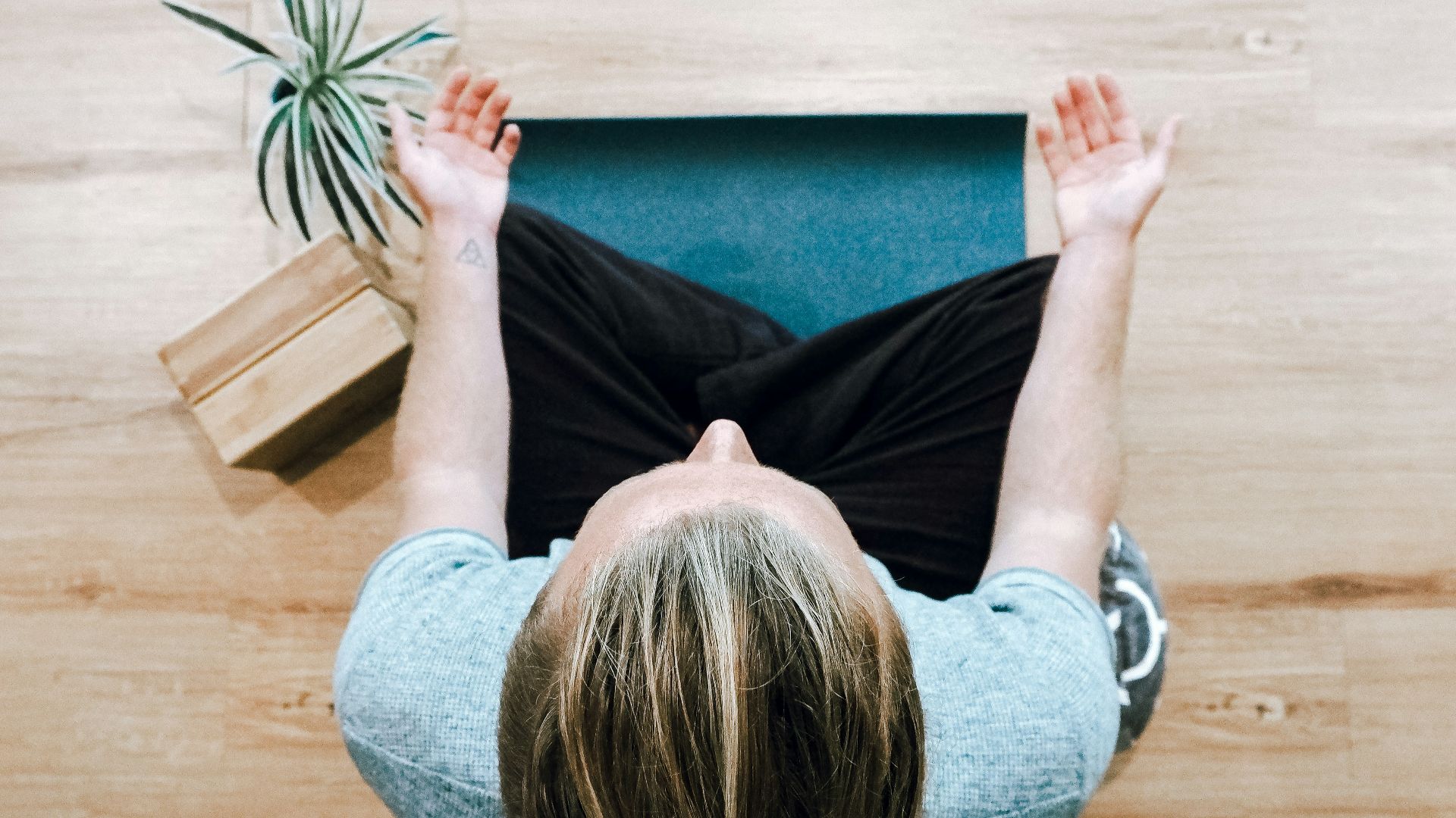 woman in black shirt and gray pants sitting on brown wooden bench