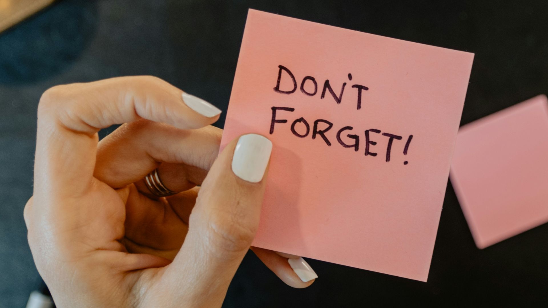 a person holding a note that says don't forget