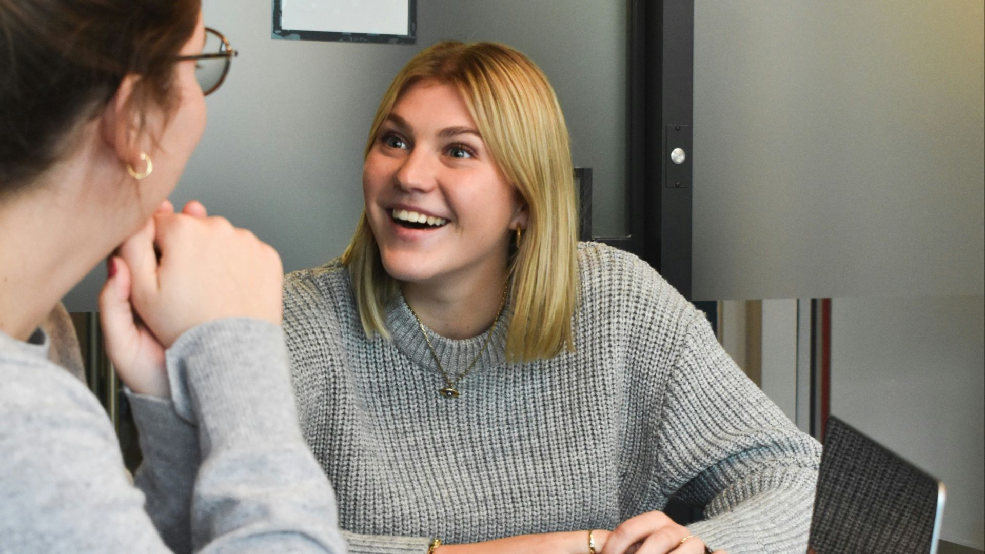 woman in gray sweater sitting beside woman in gray sweater