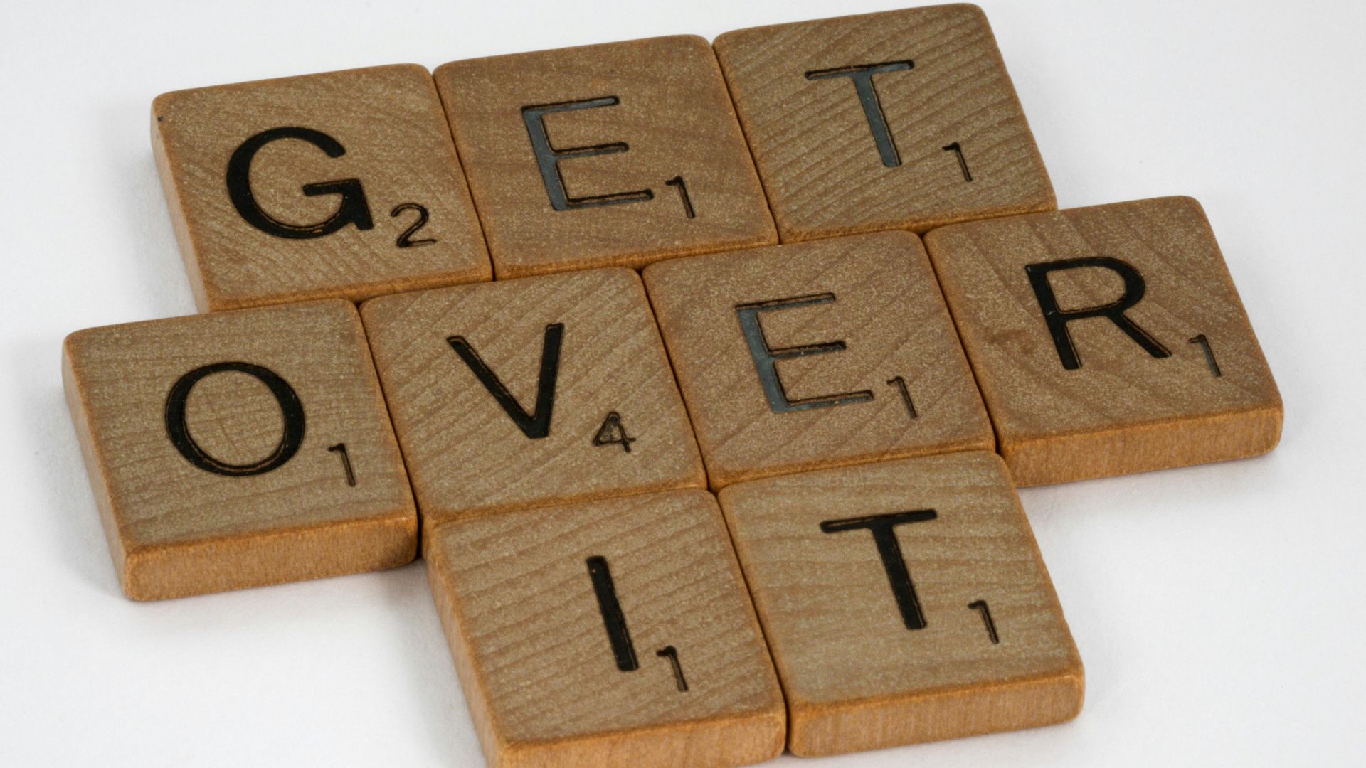 brown wooden letter blocks on white surface