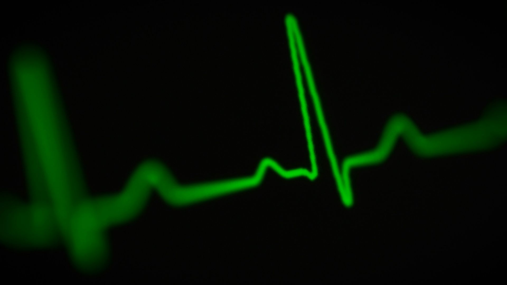 a green heart beat on a black background