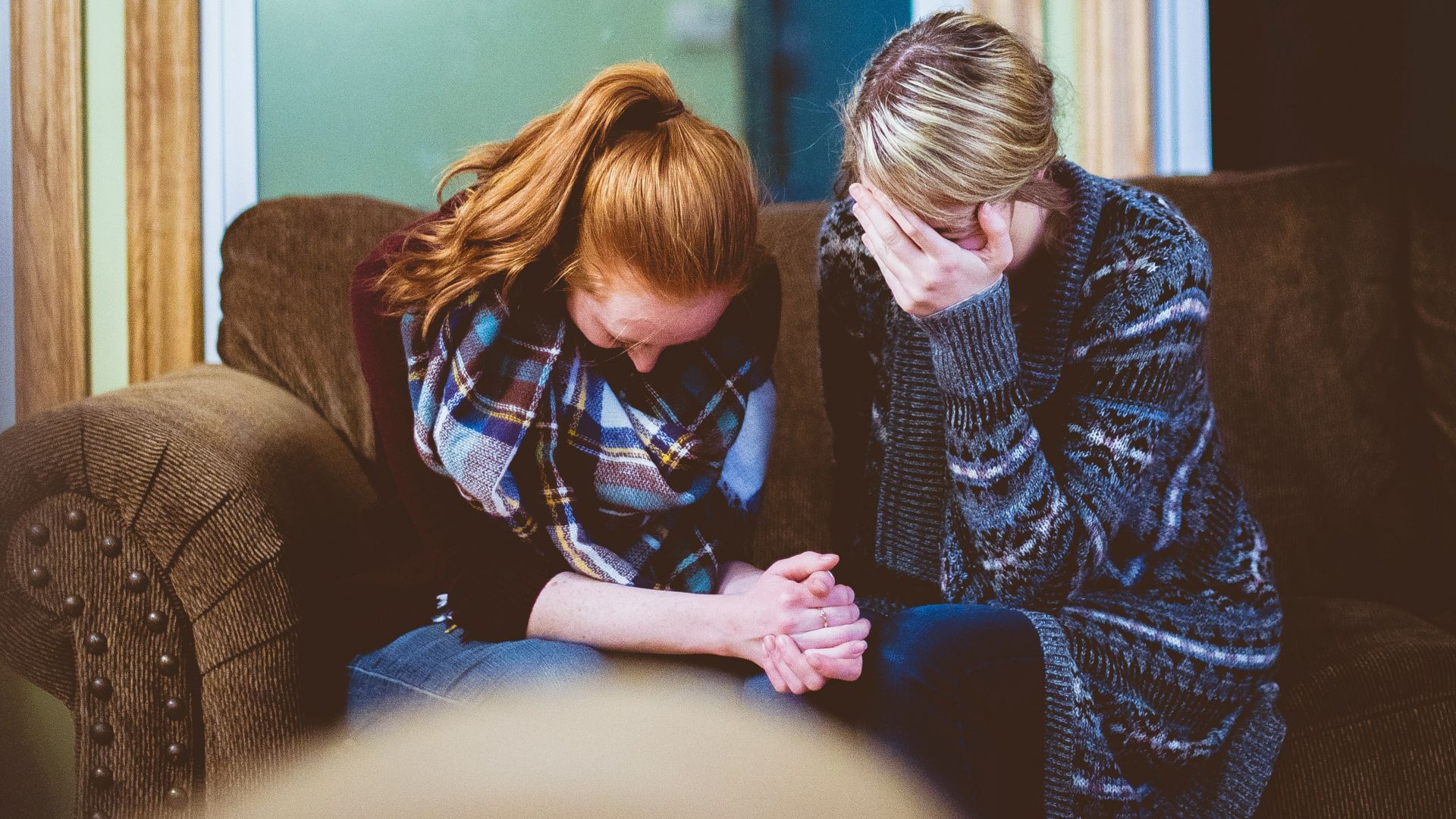 man and woman sitting on sofa in a room