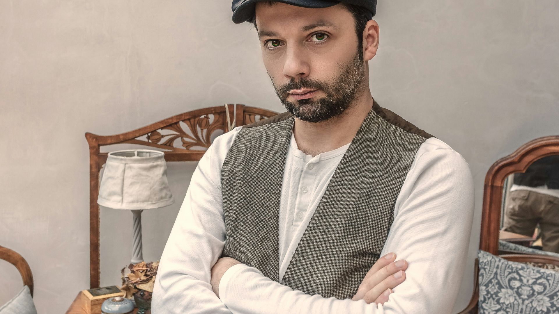 man wearing gray vest near white table lamp