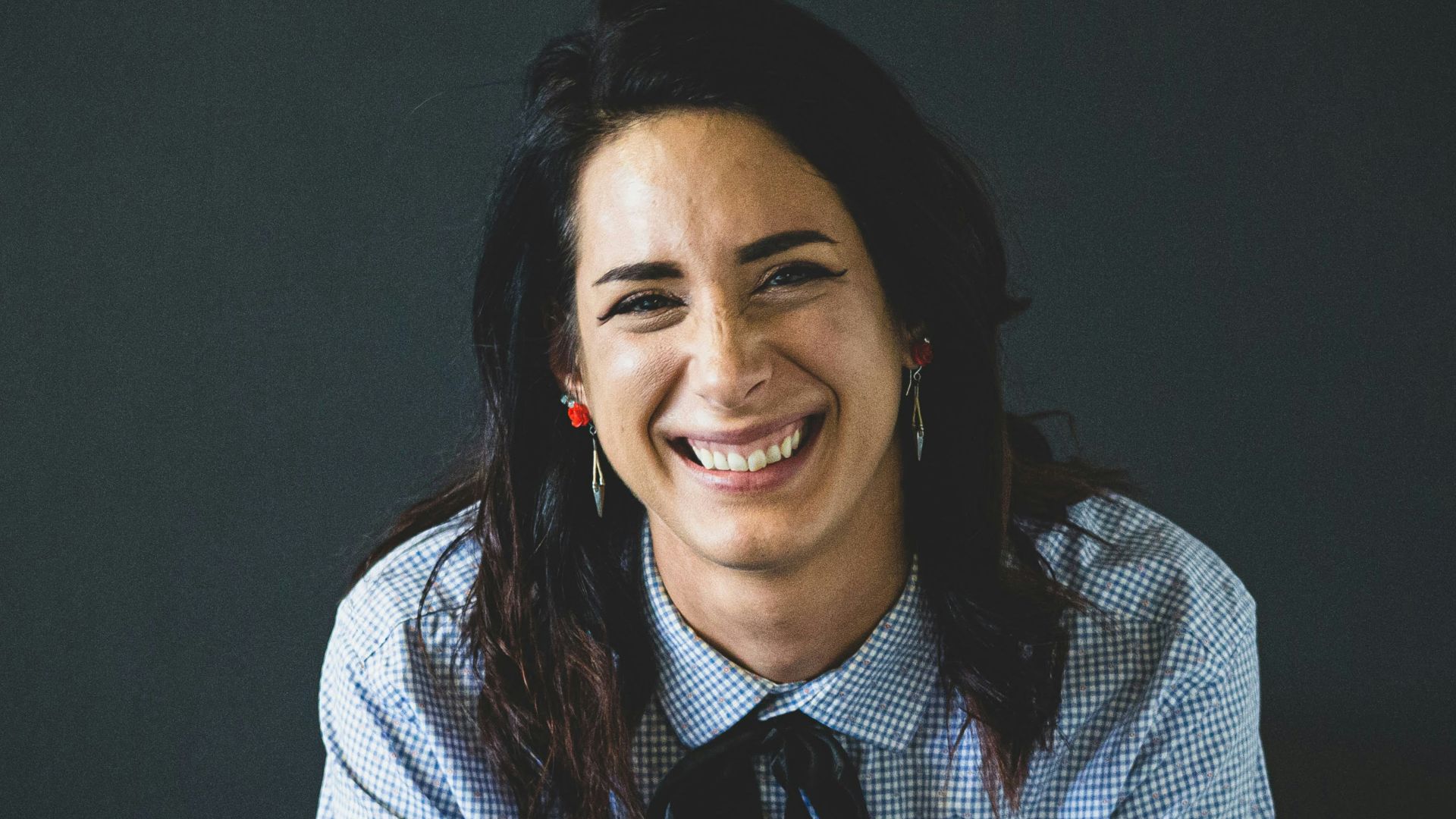 smiling woman in white and black checkered dress shirt