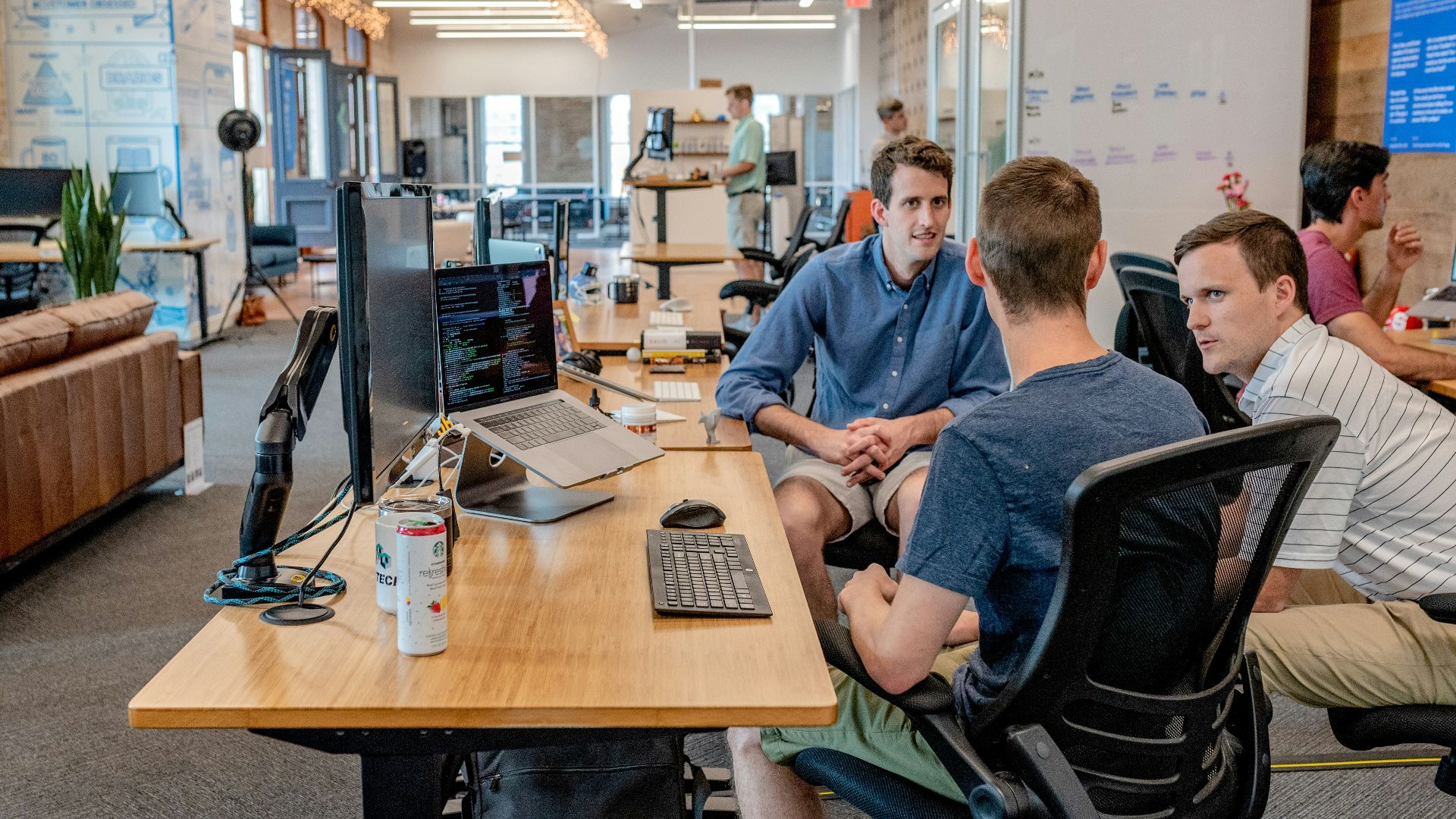 three men sitting on chair beside tables